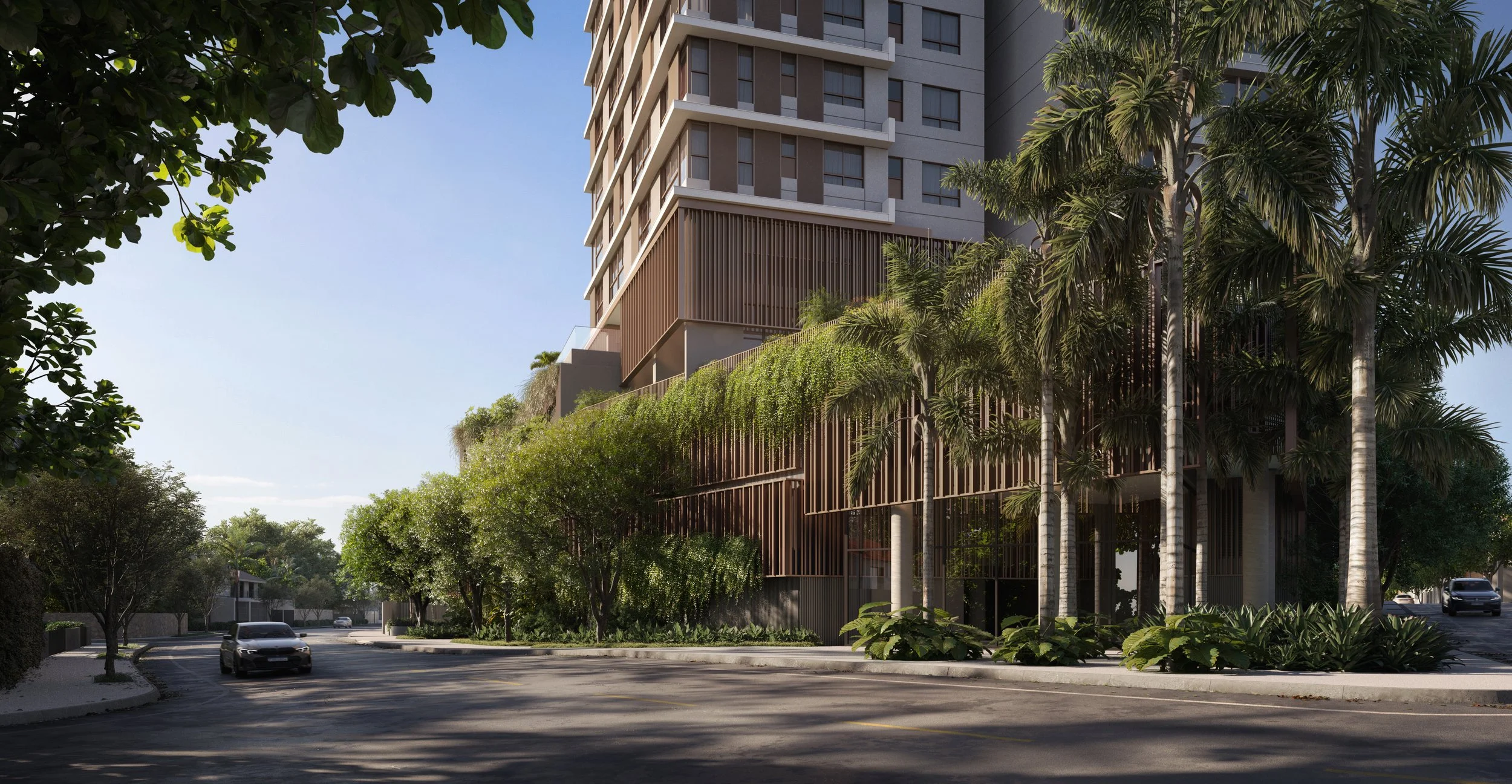 Prédio alto com fachada moderna no litoral de Santa Catarina, cercado por árvores e plantas, com carro na rua na frente e céu claro ao fundo.