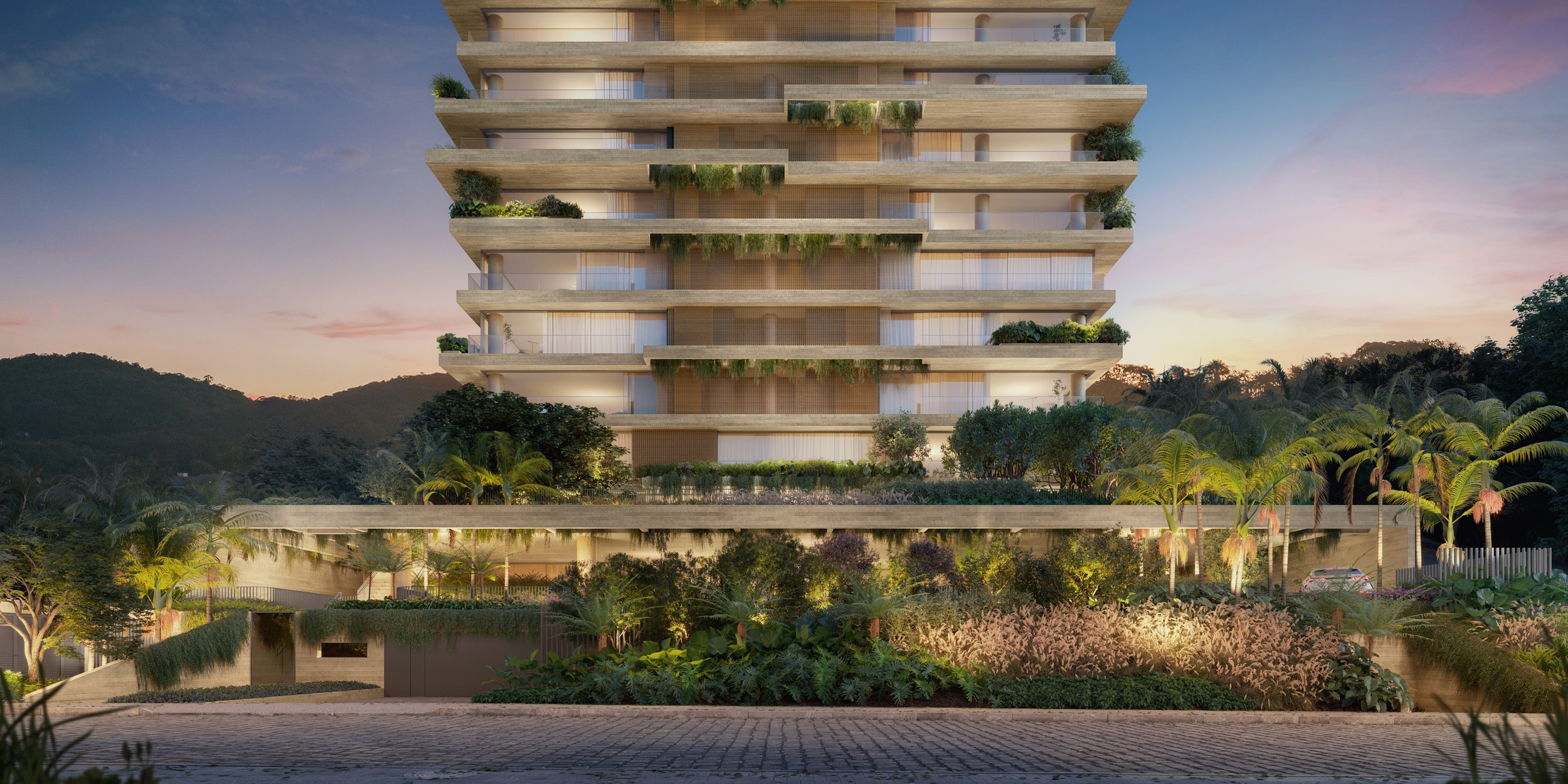 Prédio moderno de vários andares com jardins suspensos, plantas e árvores, ao entardecer, com uma paisagem de montanhas ao fundo.