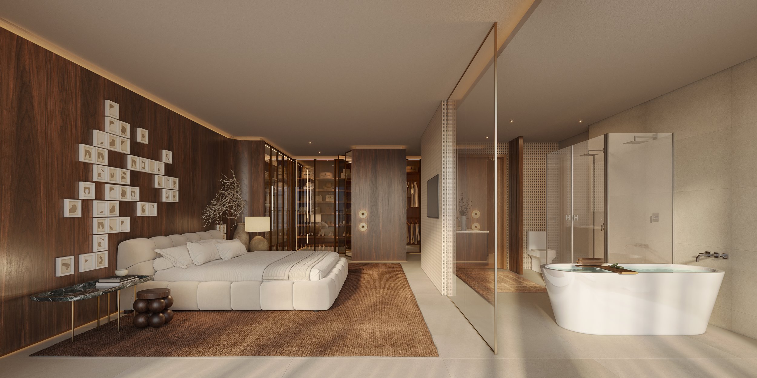 Quarto amplo com parede de madeira, cama branca, parede decorada com quadros, área de descanso com mesa de canto, luminária e decoração de árvore seca. Ao lado, banheiro com banheira branca, ducha e closet visível ao fundo.