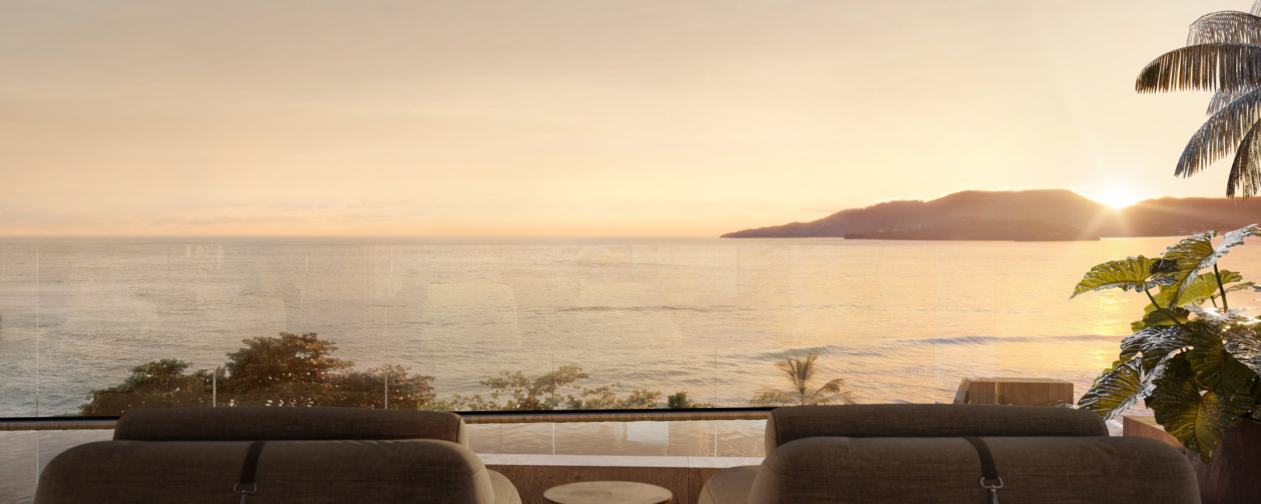 Visão de uma praia ao pôr do sol vista de uma sala com janelas grandes, duas cadeiras e plantas no interior.