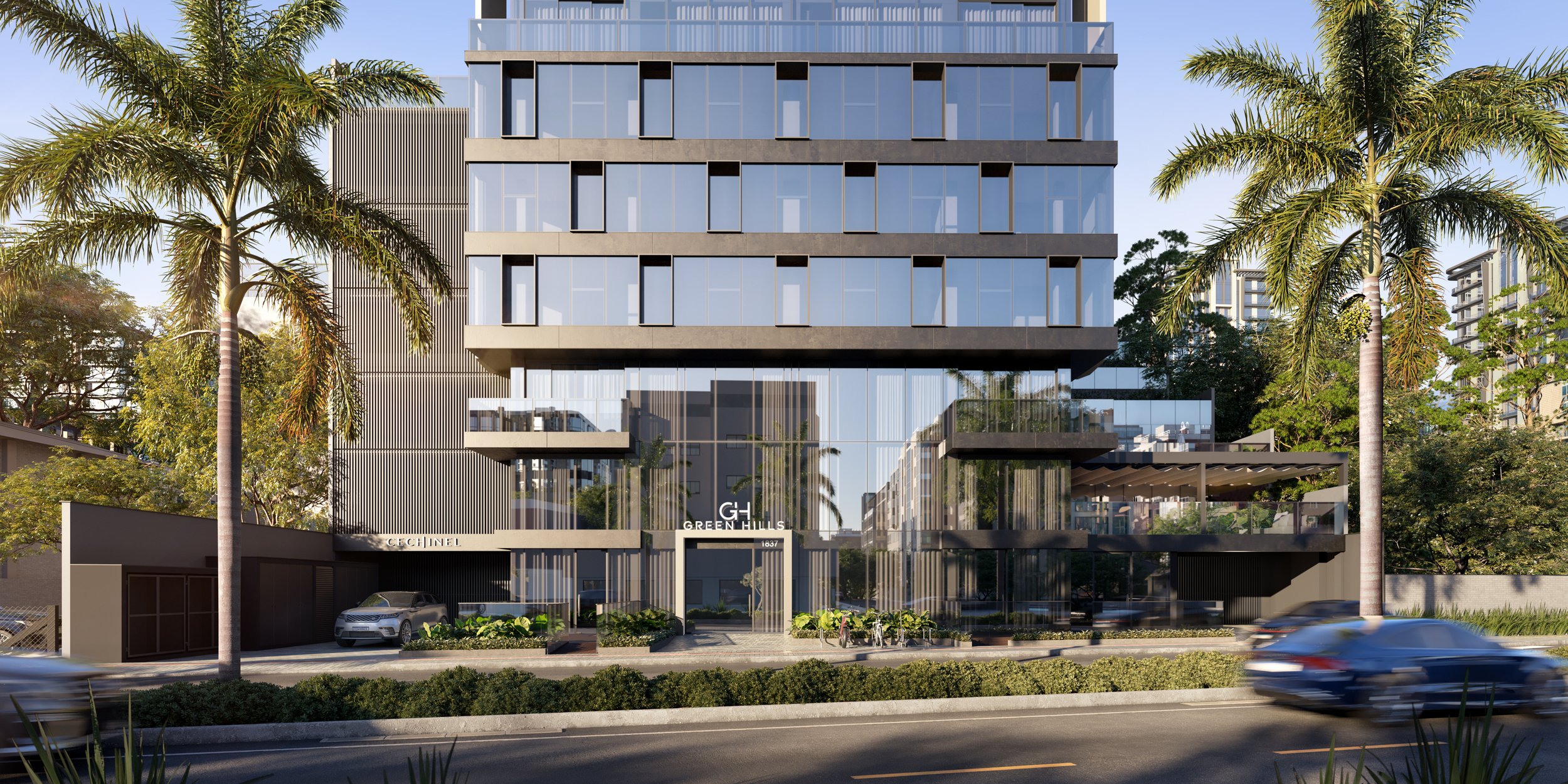 Arranha-céu moderno com fachada de vidro, vistoriado por palmeiras, com entrada principal, ao lado de veículos circulando na rua.