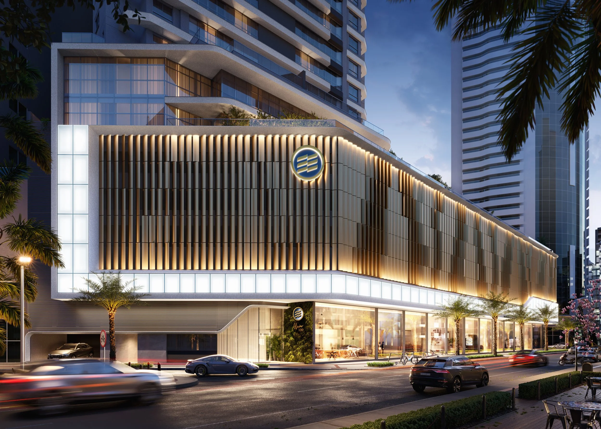 Edifício moderno em Balneário Camboriú, com iluminação na fachada, localizado em uma rua movimentada à noite, com carros e árvores ao redor.
