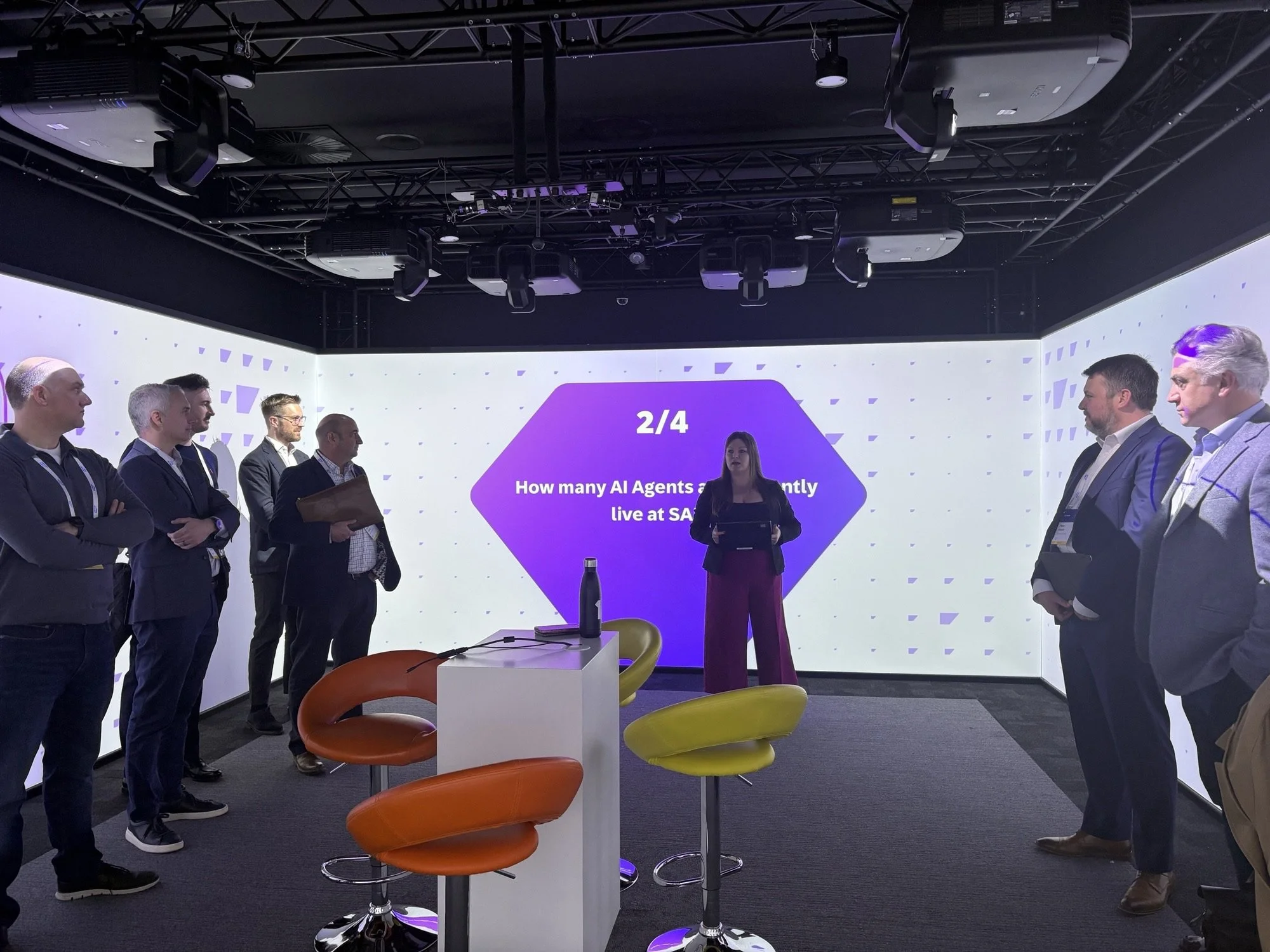 Group of professionals attending a presentation in a modern conference room with a digital screen displaying a quiz question.