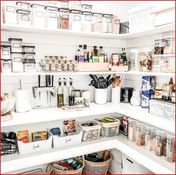 Pantry with organized shelves holding spices, canned goods, utensils, and storage containers.