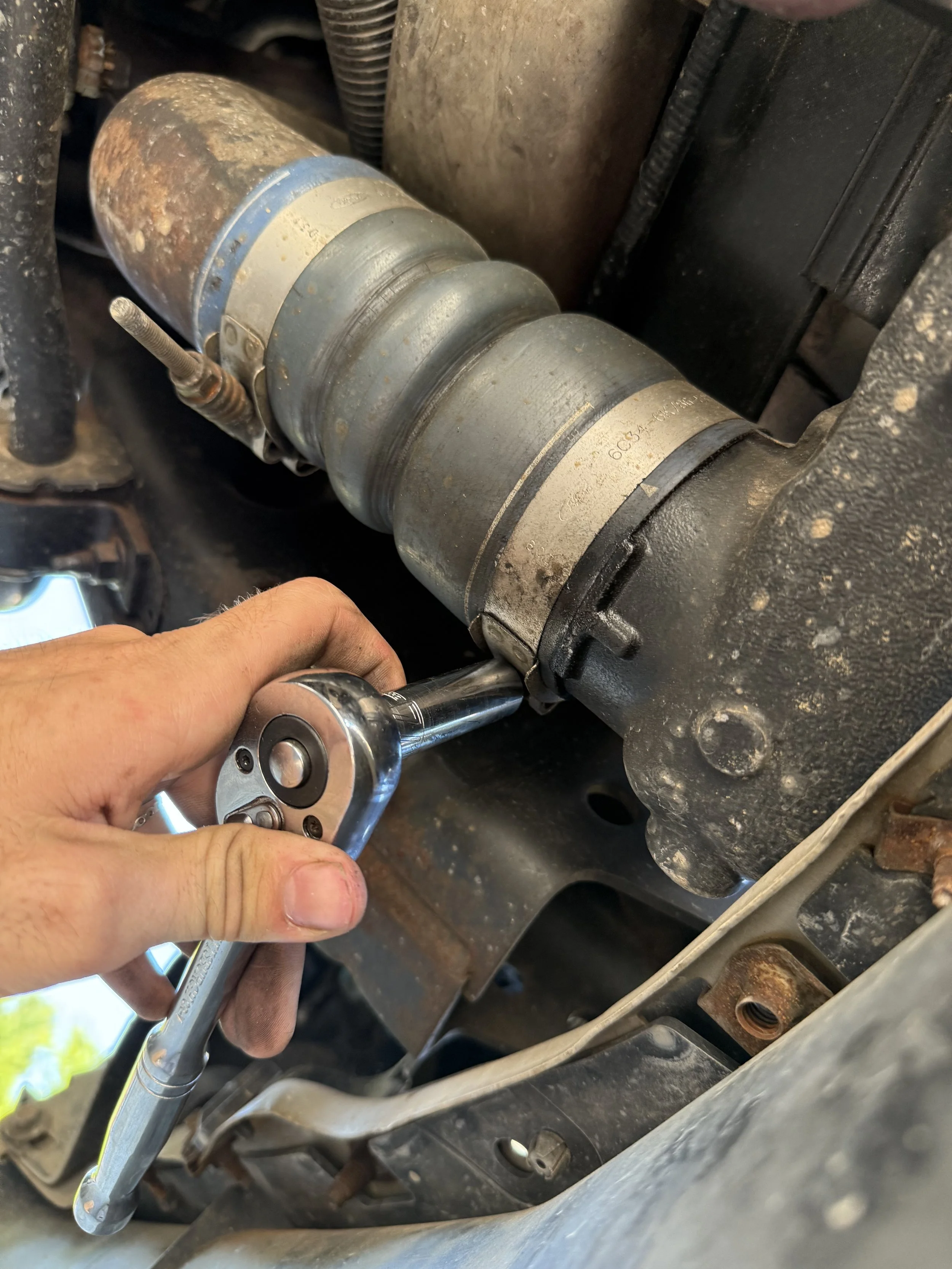 Technician servicing a Ford Powerstroke 6.4L turbo connection on-site
