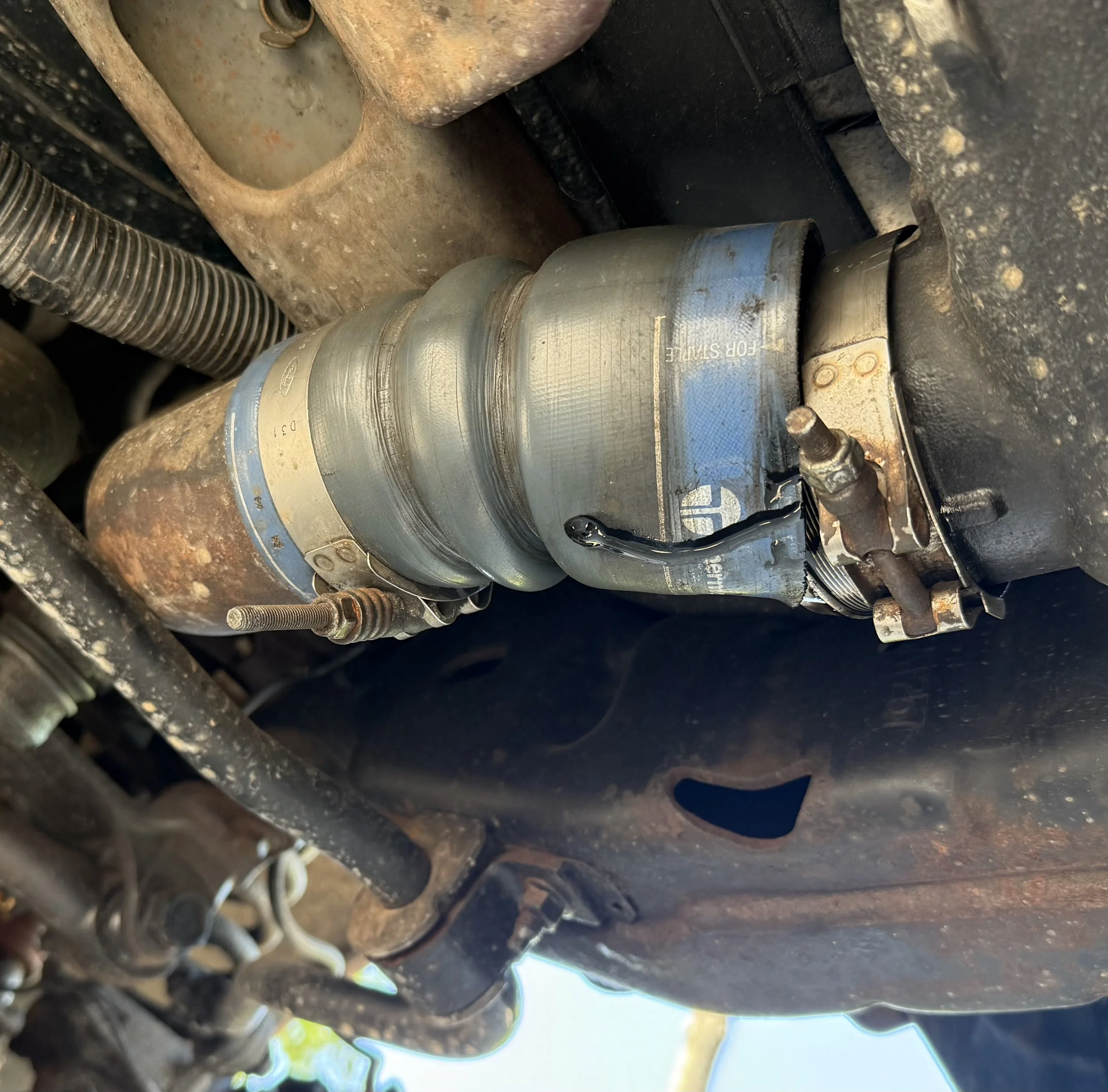 Technician servicing a Ford Powerstroke 6.4L turbo connection on-site