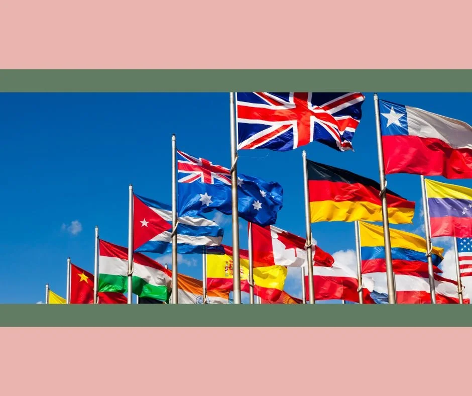 Un groupe de drapeaux nationaux flottant contre un ciel bleu, comprenant des drapeaux du Royaume-Uni, de l'Australie, du Canada, de l'Allemagne, de l'Espagne, de la France, de l'Italie, du Vietnam, des États-Unis, et d'autres pays.