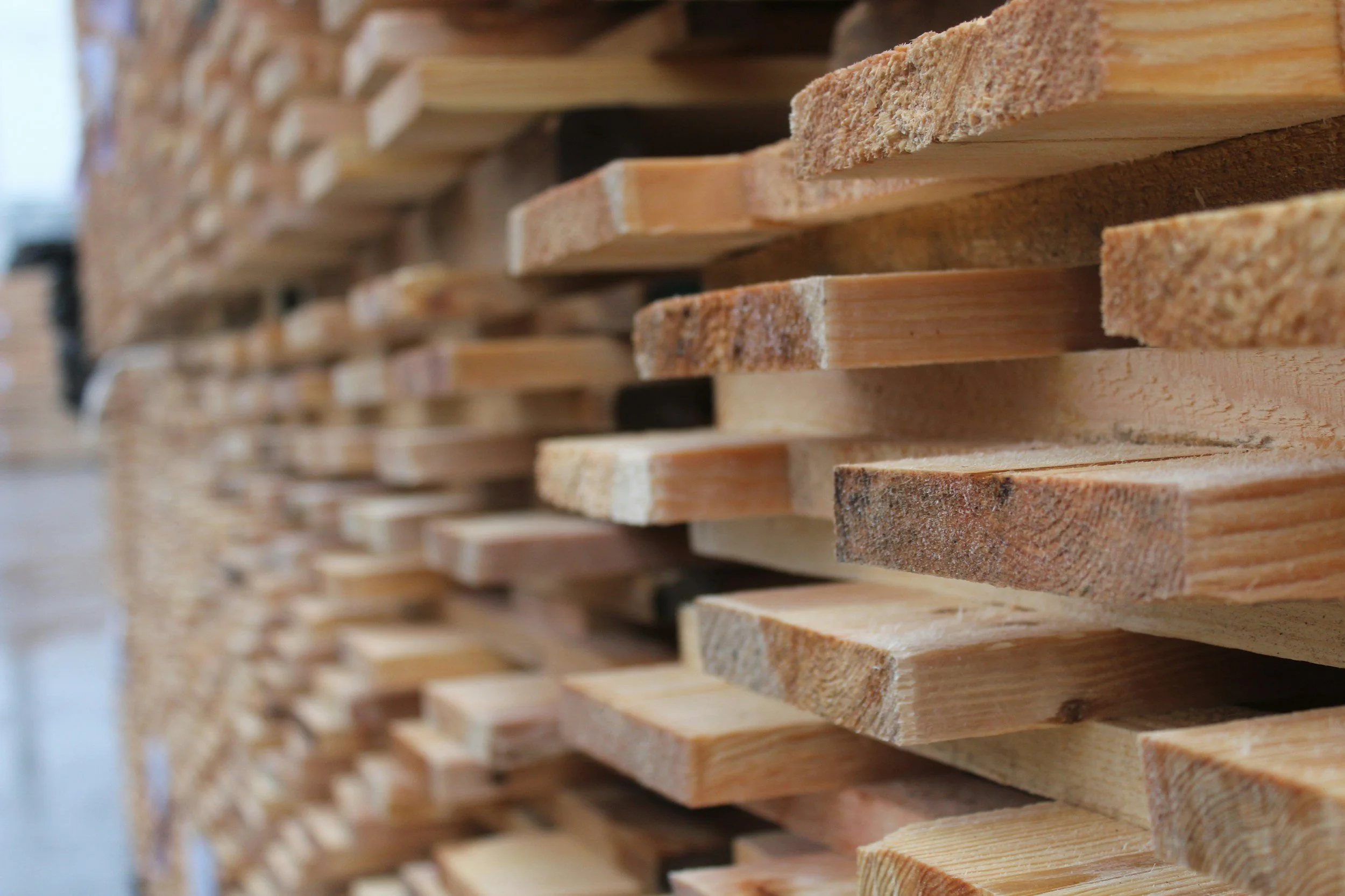 Close-up view of stacked wooden planks in a lumber yard or workshop.