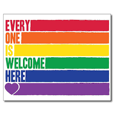 A rainbow-colored sign with the message 'Everyone One is Welcome Here' in rainbow colors, with a purple heart at the bottom left corner.