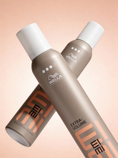 Duas latas de spray de cabelo Wella EIMI Extra Volume, cor cinza com tampas brancas, posicionadas contra um fundo linear suave.