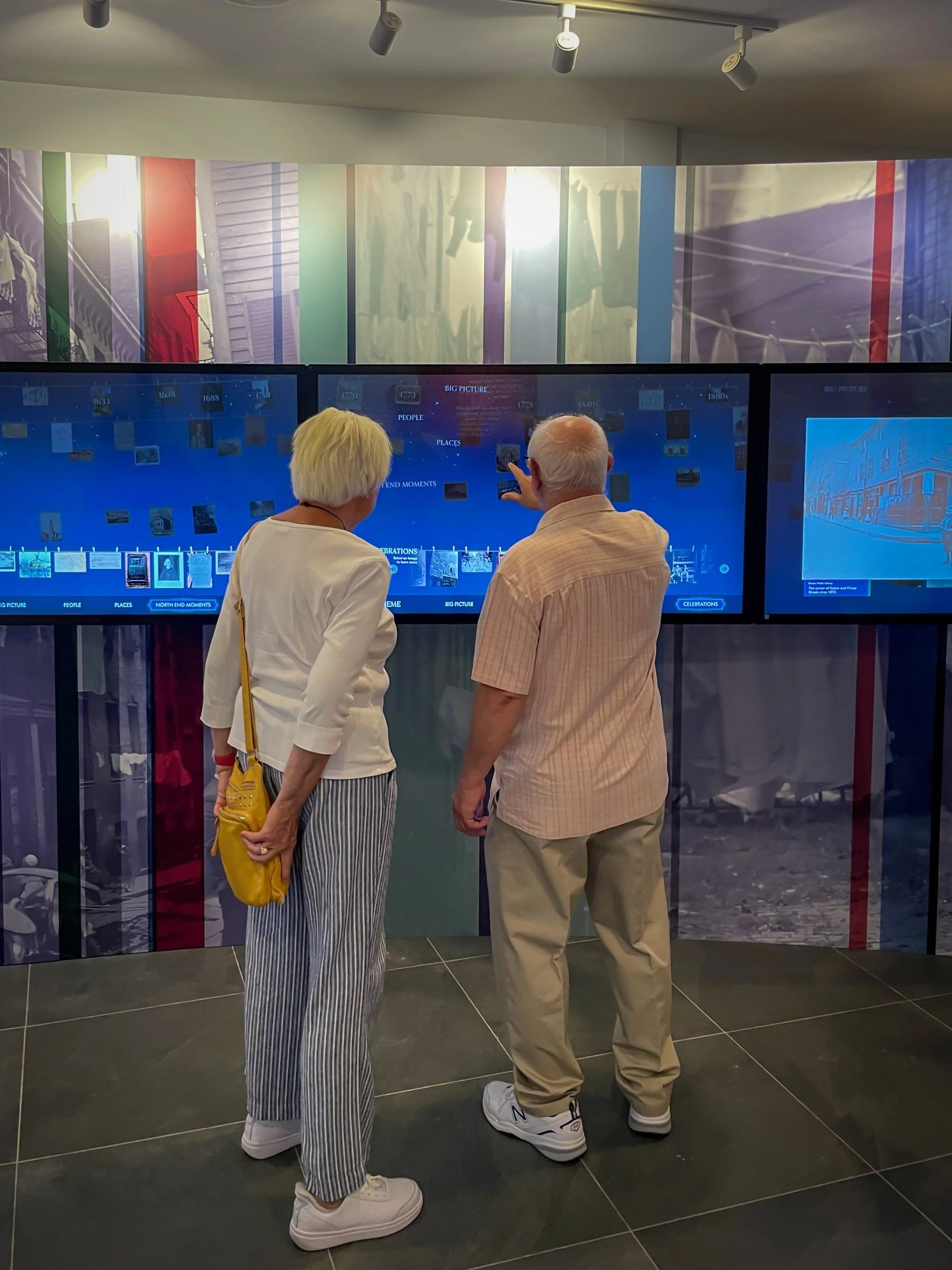 Visitors at the main gallery's wall of interactive screens at the North End Historical Museum.