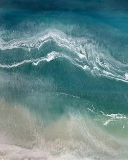 Aerial view of ocean waves crashing onto the shoreline.