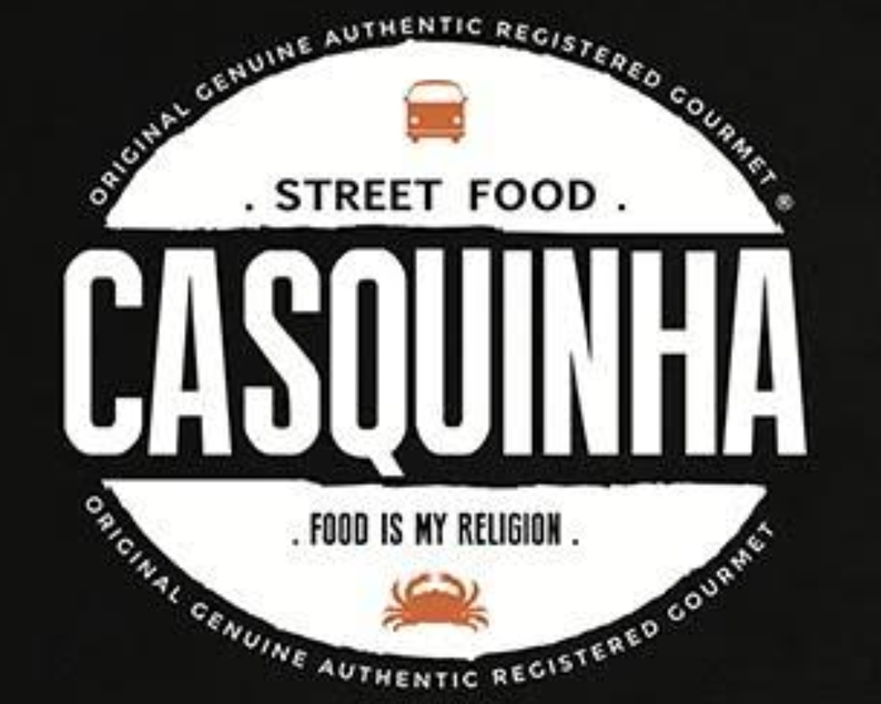 Black circular logo with white and orange elements. Top features a small orange bus icon with text 'Street Food' around it. The main text in large white capital letters is 'CASQUINHA'. Below it, a small orange crab icon and the phrase 'Food is my religion'. The outer circle has the phrase 'Original Genuine Authentic Registered Gourmet' repeated around the border.