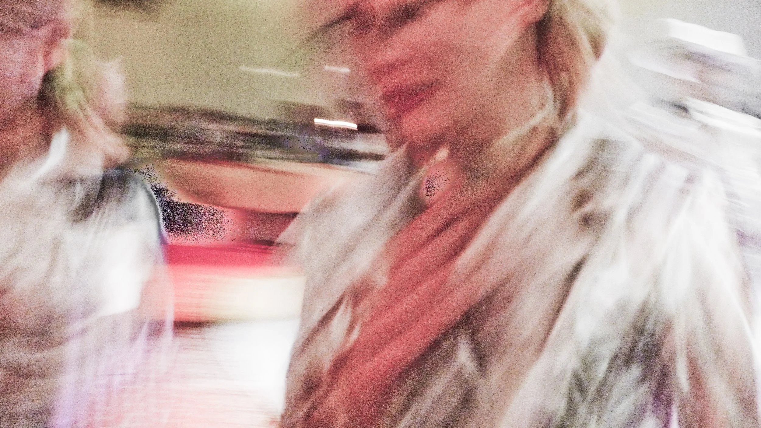 A person with blonde hair wearing a striped shirt. The image is blurry and appears to be in motion.