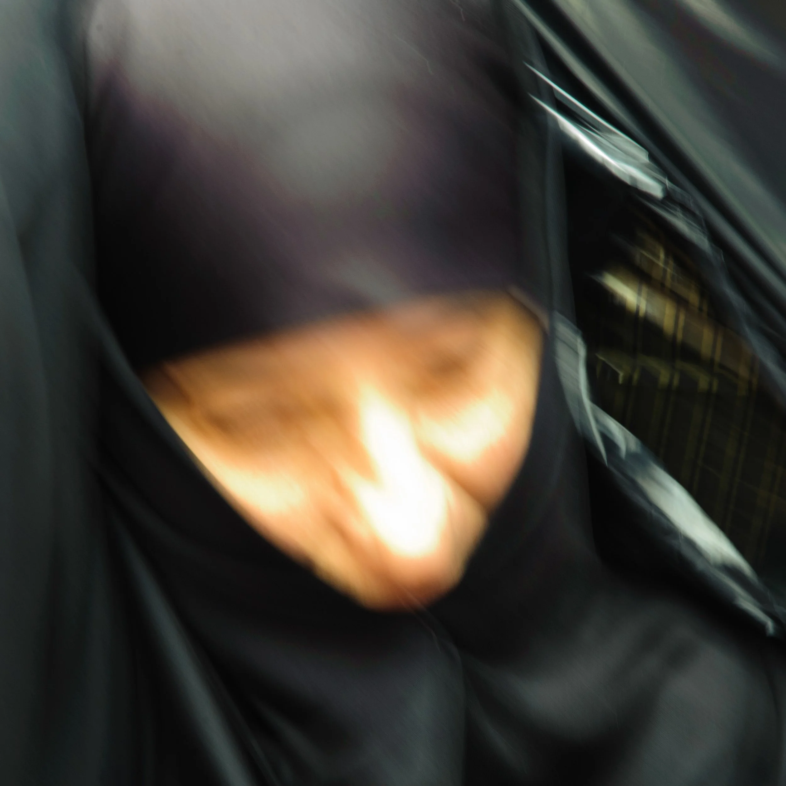 Blurred photo of a person's lap with a visible knee and part of their shirt and pants.