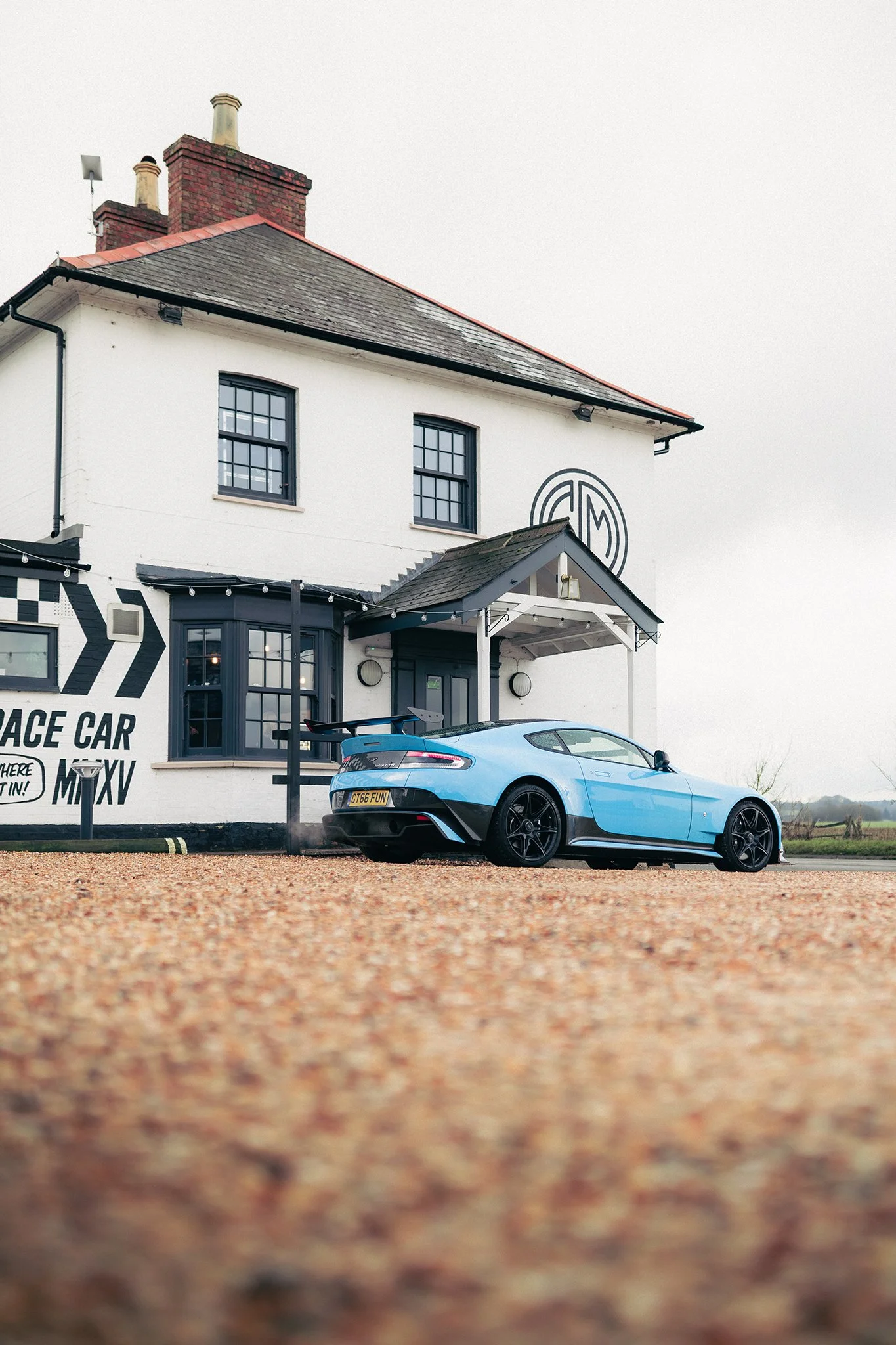 A Fugplatz Blue Aston Martin Vantage GT8 outside of Caffiene and Machine