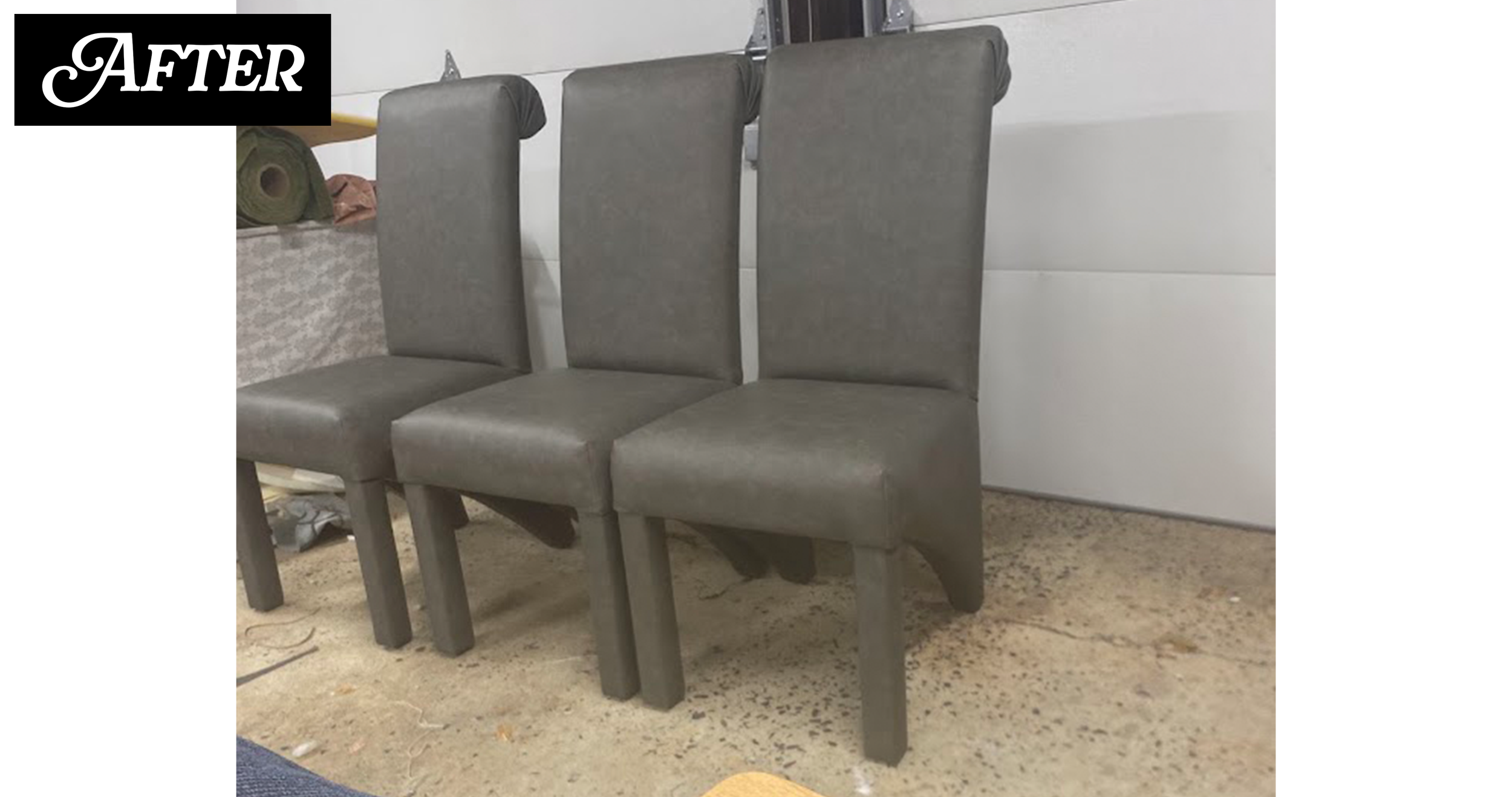 Four gray high-backed chairs arranged in a row facing away from a white wall. The chairs have cushioned seats and backs and are situated on a speckled concrete floor.