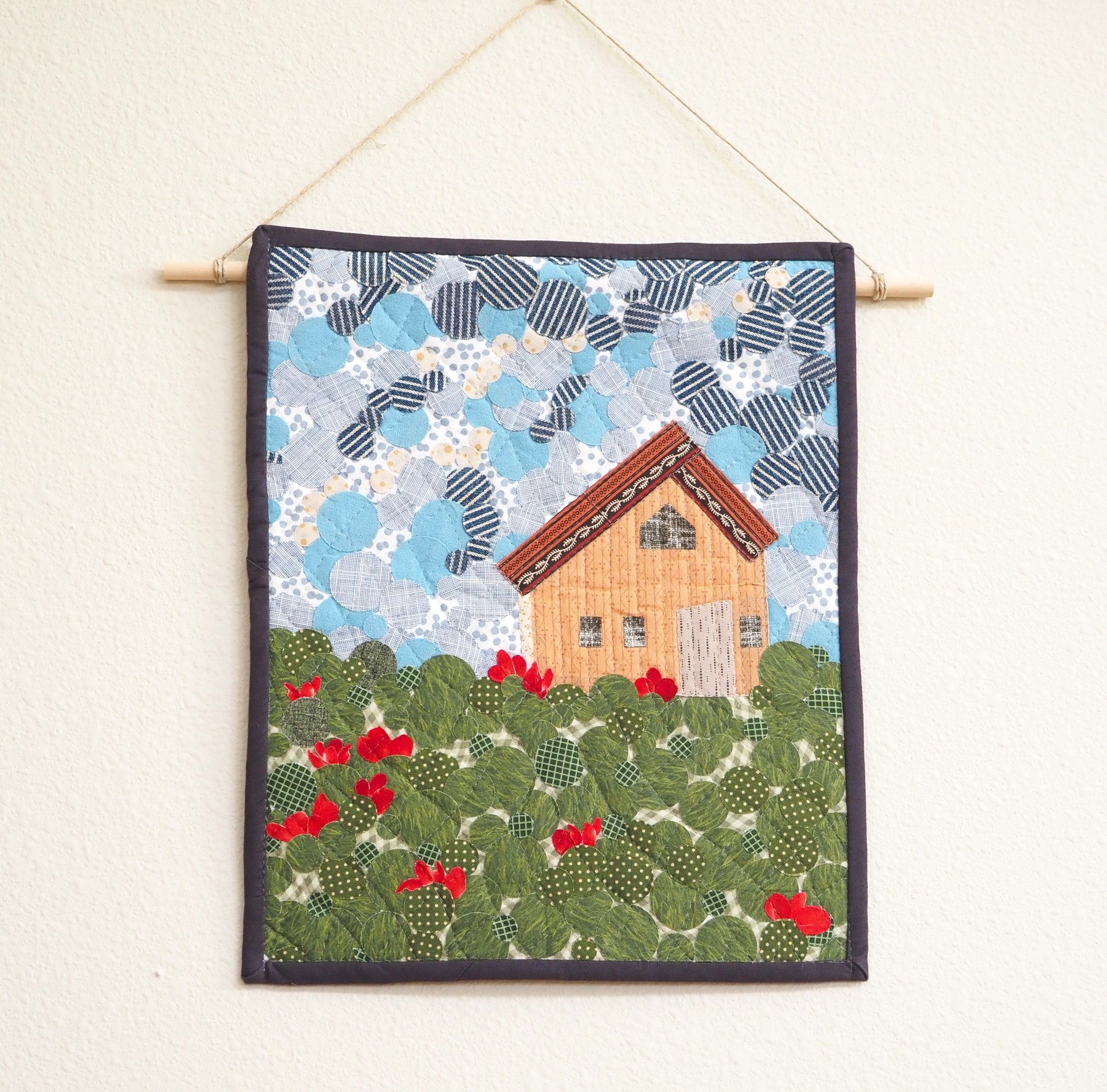 Bring heirloom warmth and rustic character to your home with the Cottage Landscape Art Quilt.
