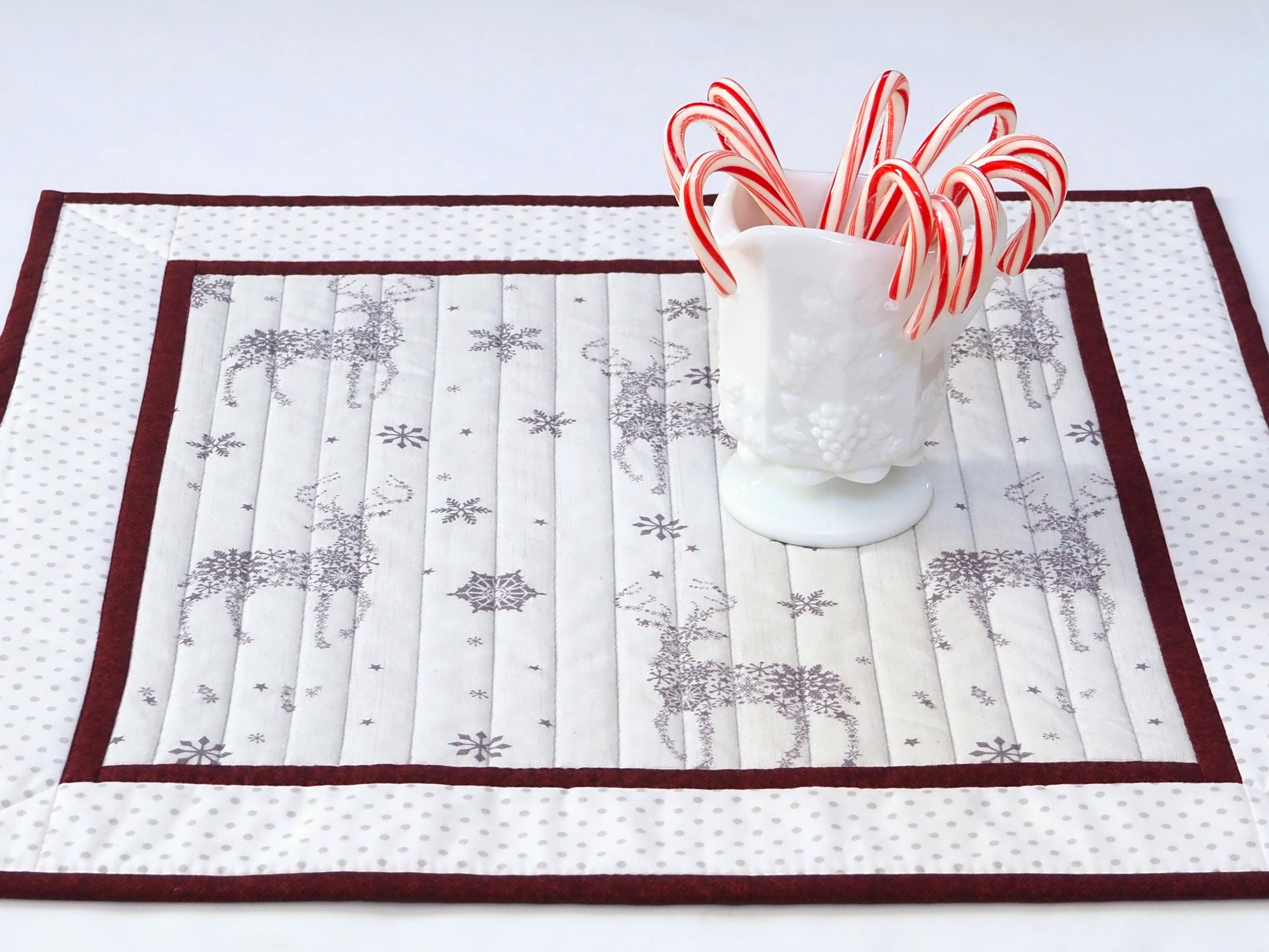 Handmade quilted Christmas reindeer table topper 20x20 styled with holiday candy dish