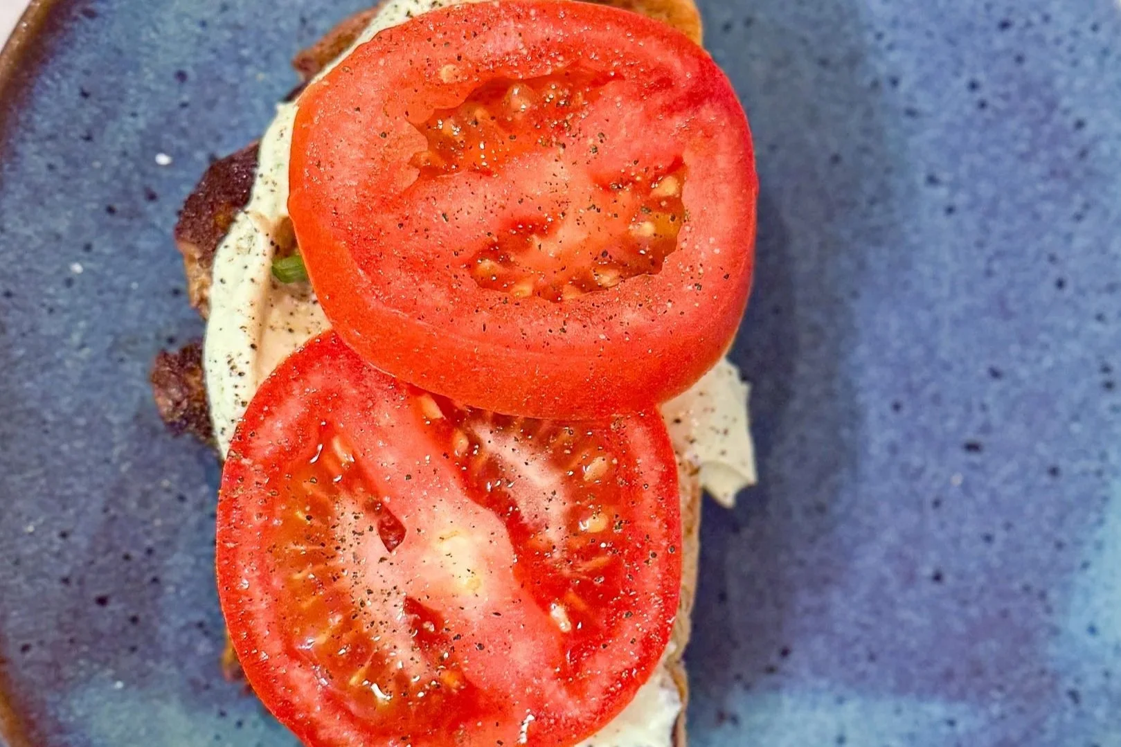 sourdough toast, whipped cottage cheese and avocado, with sliced tomatoes on top