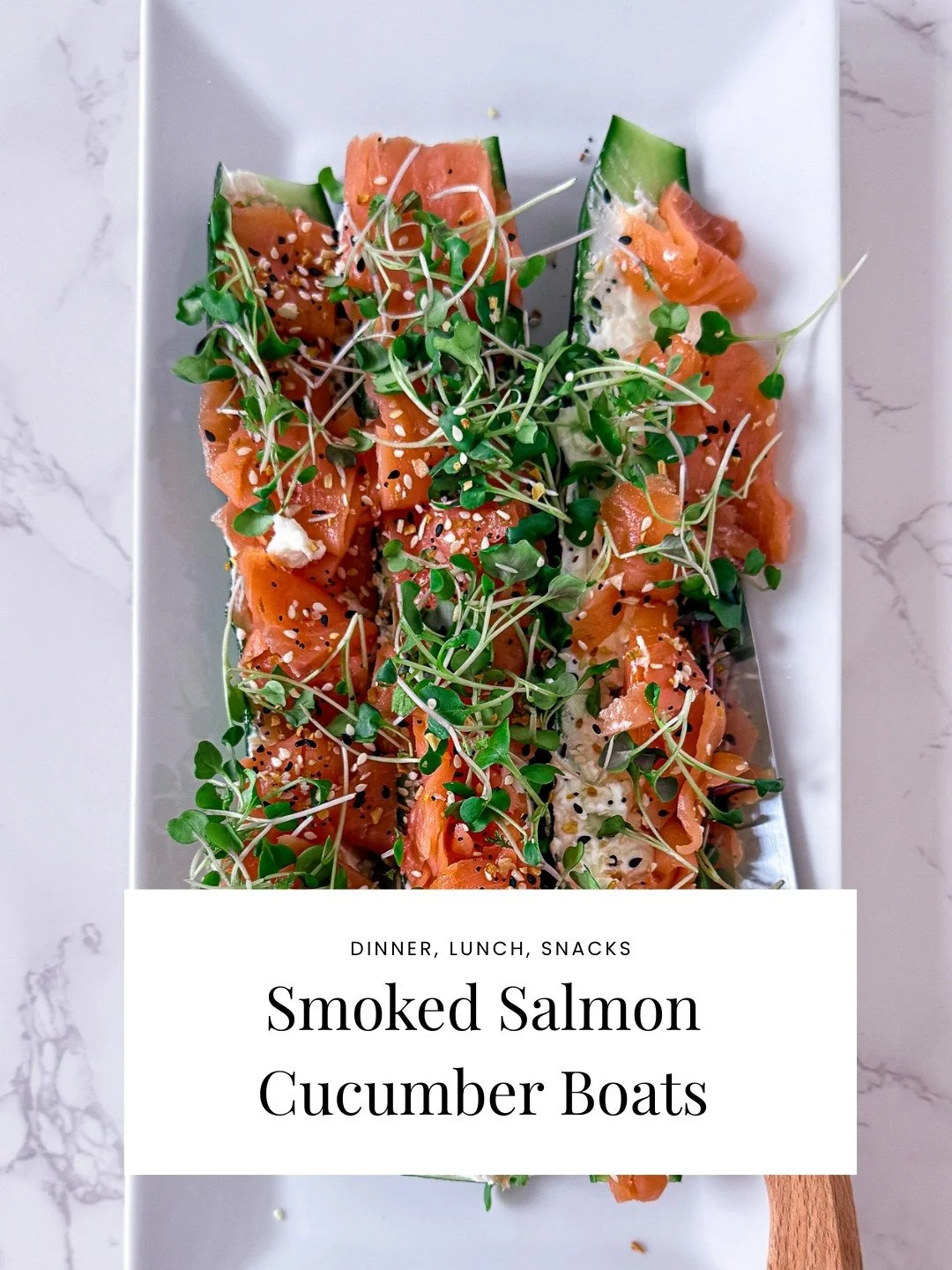 A dish of smoked salmon with cucumber slices, topped with microgreens, sesame seeds, and black and white seeds, served on a white rectangular plate.