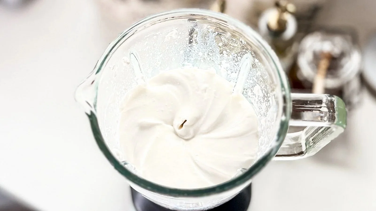 A blended creamy mixture in a blender, shown from above with a smooth swirl pattern.