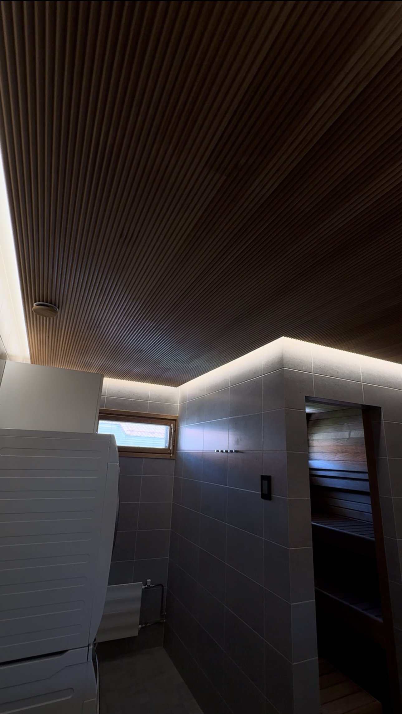 Kylpyhuoneen epäsuoravalaistus alaslasketun katon yläpuolella johon lisättiin myös himmennin