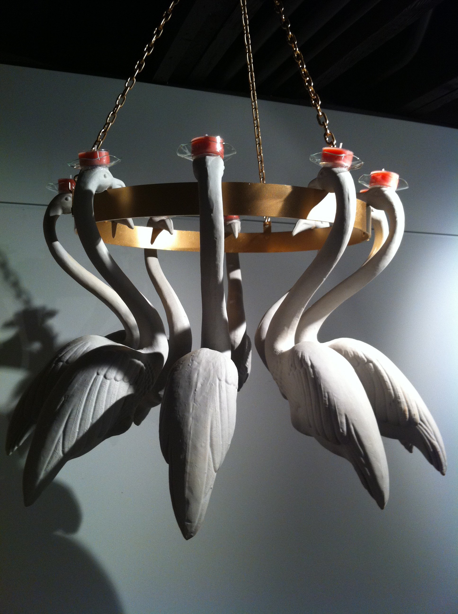 Chandelier with swan-shaped decorations hanging from chains.