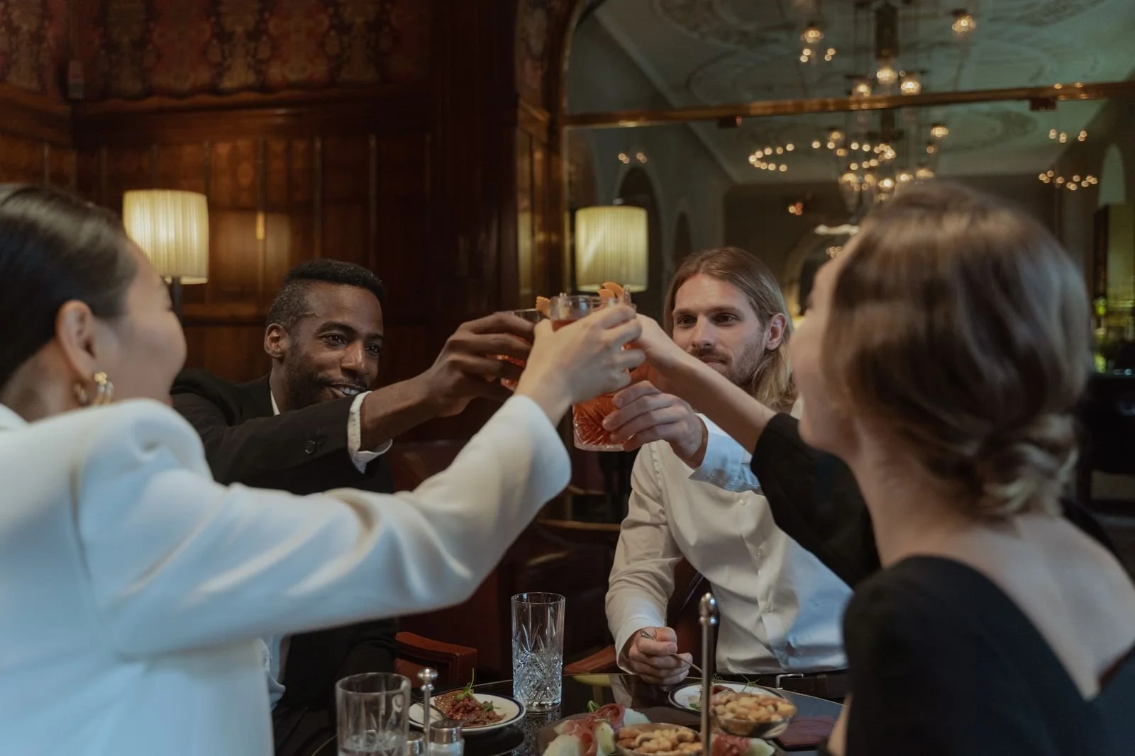 Guests sharing a toast around a restaurant table. Stock photograph by Ron Lach, Pexels.