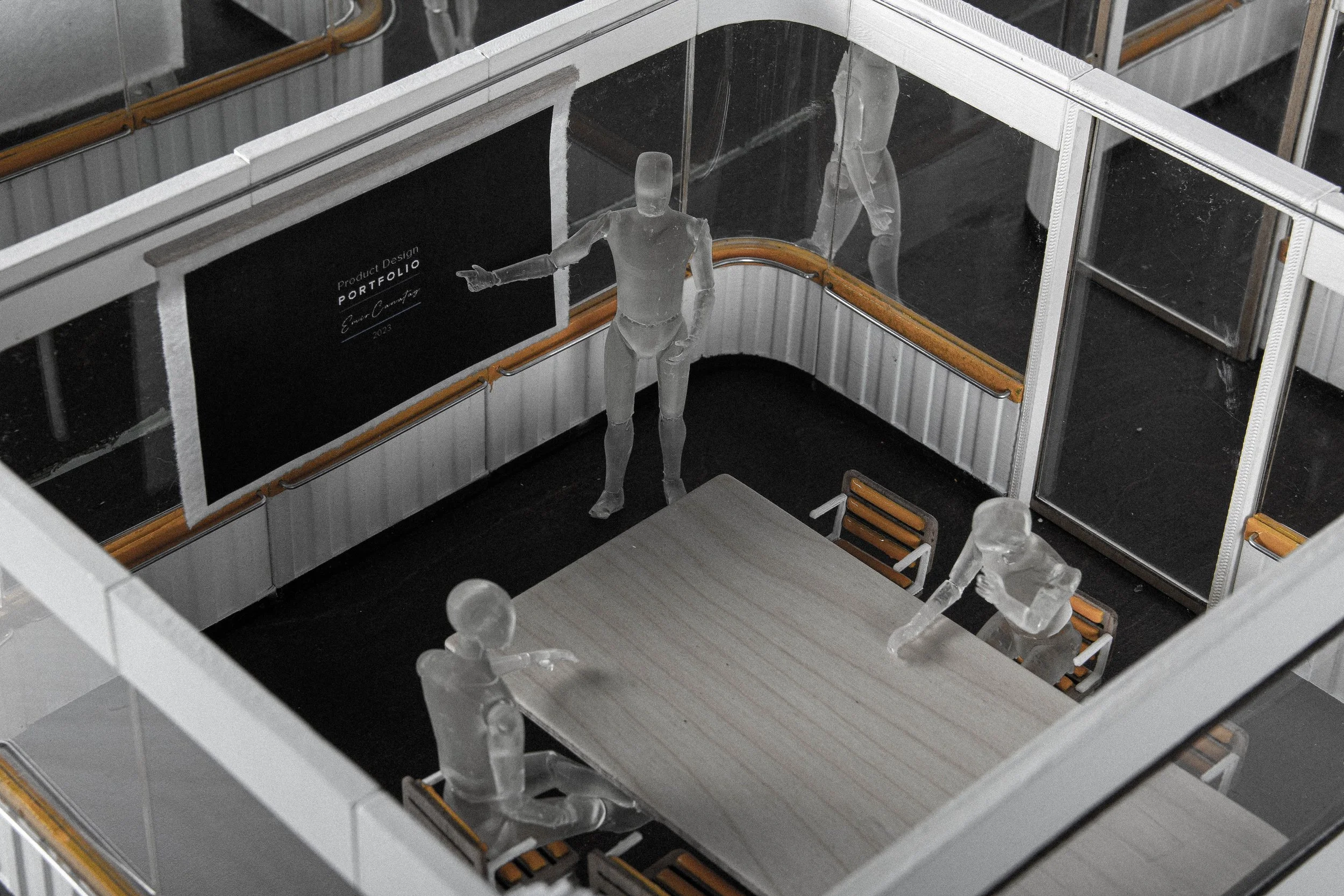 Miniature model of a conference room with transparent figures of four people around a table, a blackboard with 'Portfolio' written on it, and glass walls.