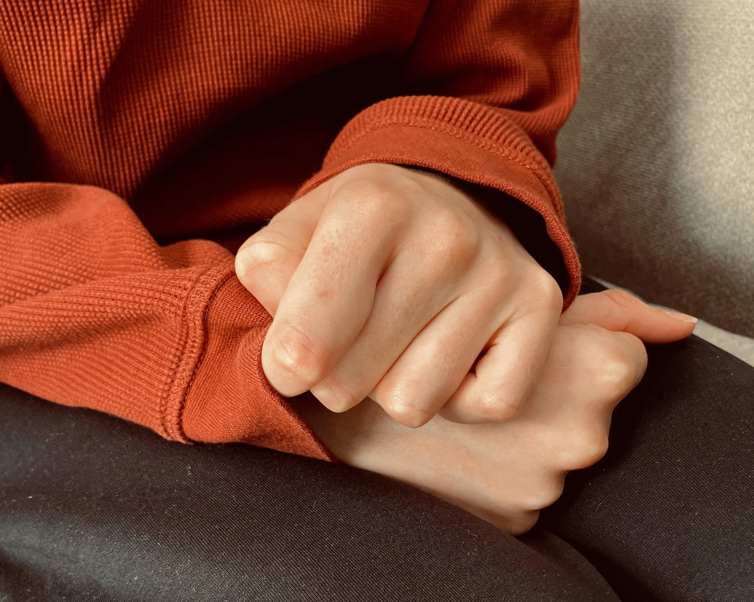 Hands gripping a cosy sweater sleeve. Demonstrating Millie Parker's counselling service in North London (Muswell Hill and East Finchley)
