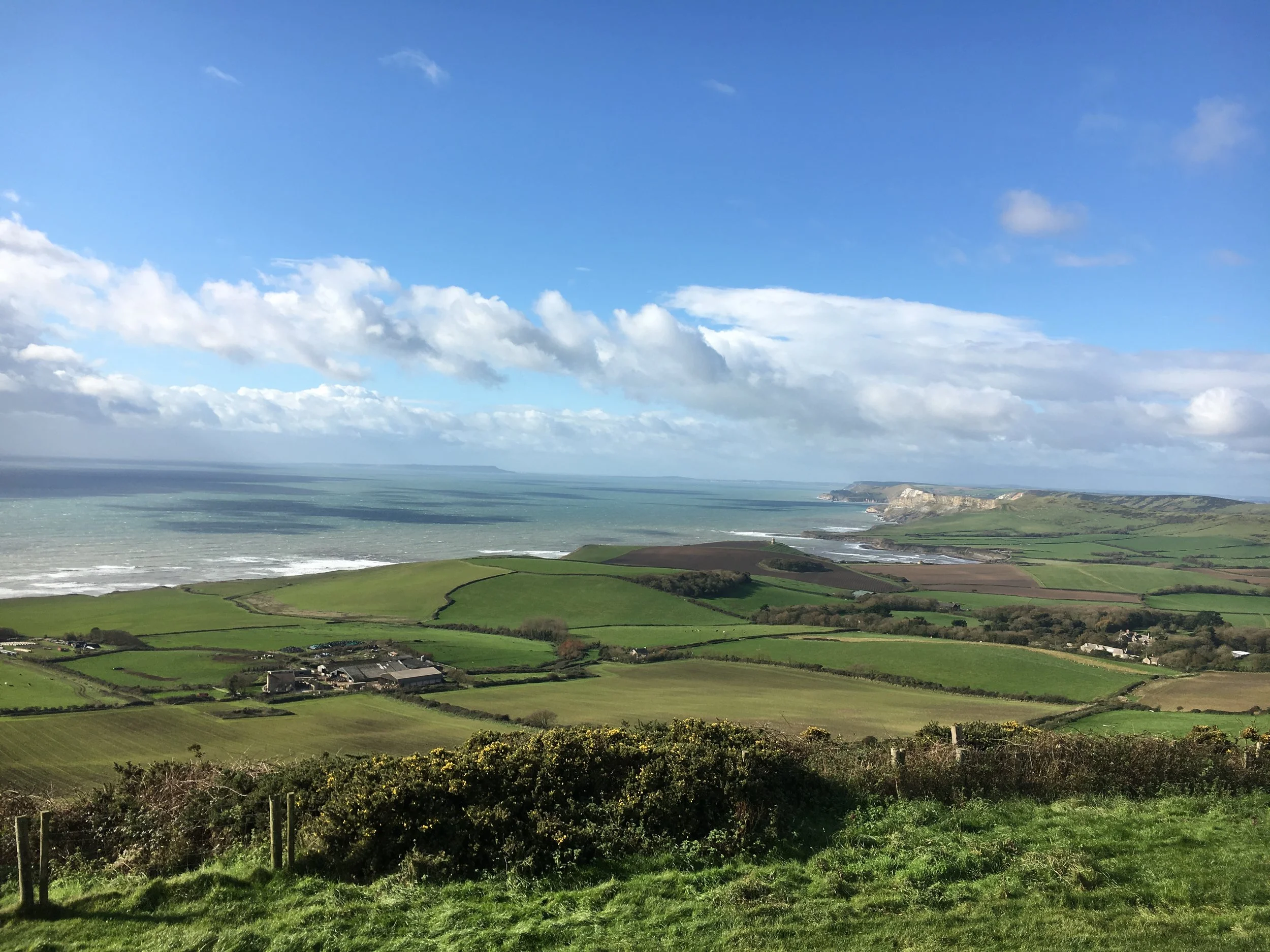 Image of landscape showing green rolling hills and blue sky with clouds illustrating how therapy can bring calm