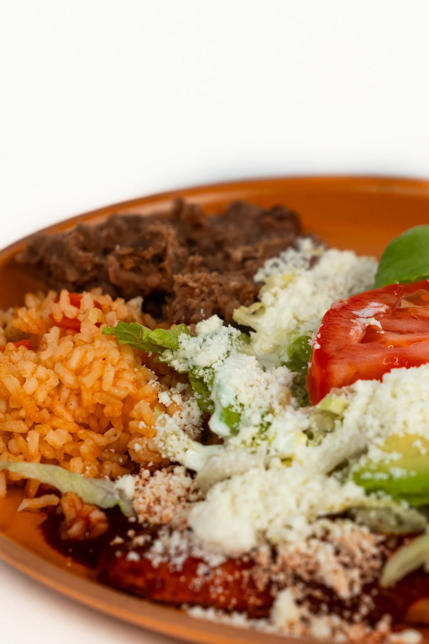 Close-up of a colorful Mexican meal featuring rice, beef, tomato, lettuce, and cheese.