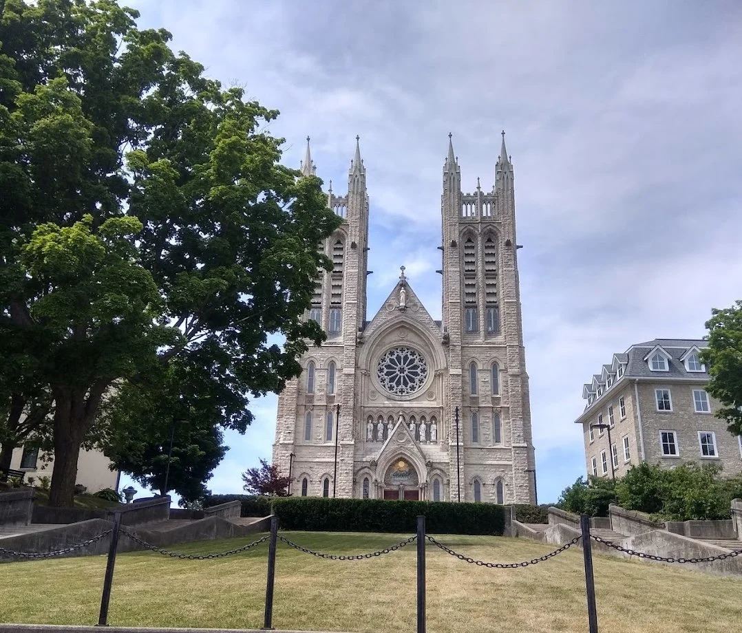 Basilica of Our Lady in Guelph, Ontario, surrounded by trees and green space.