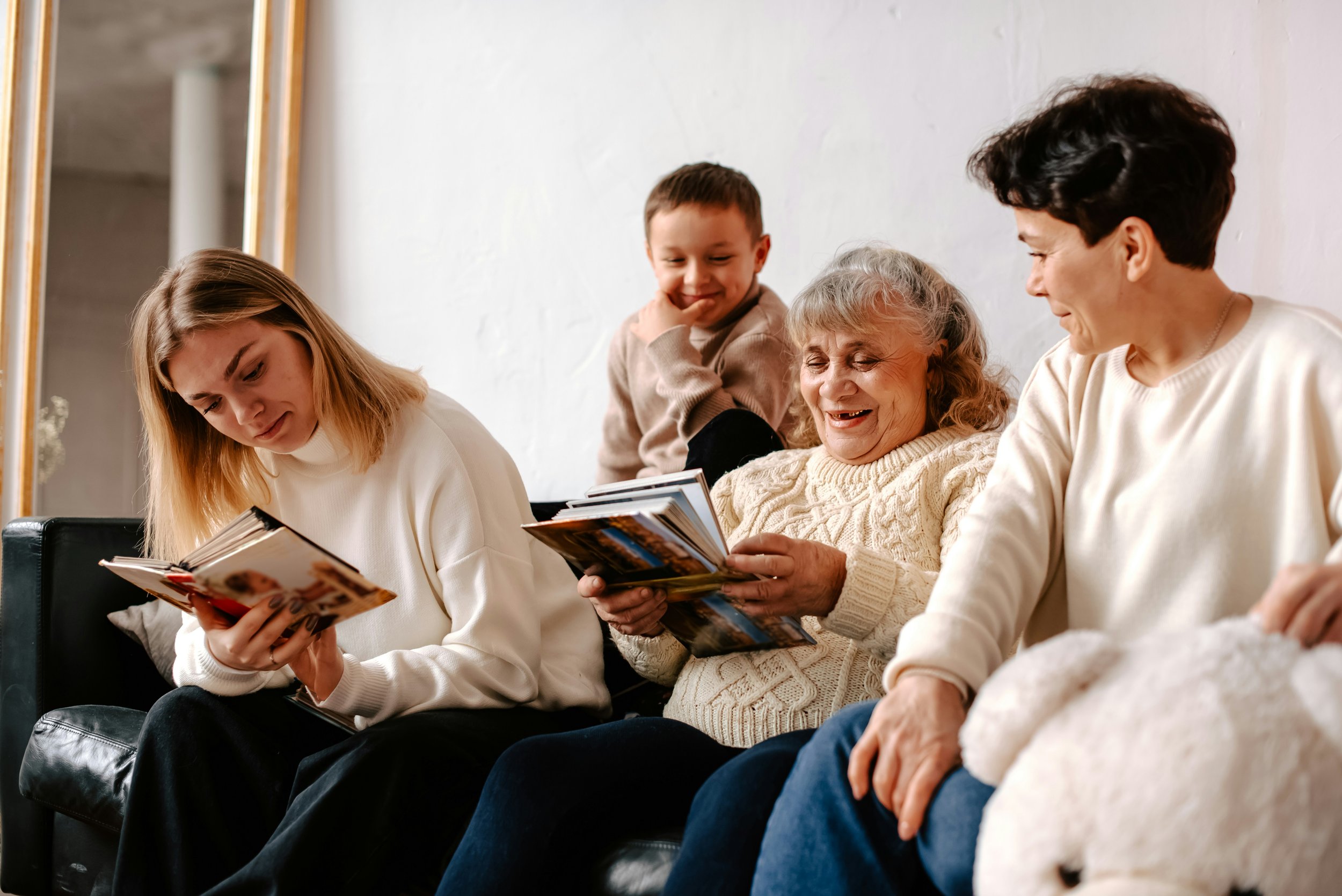 Senior woman sitting with family members at home looking through photo albums together, reflecting supportive non-medical home care in Waterloo Region.