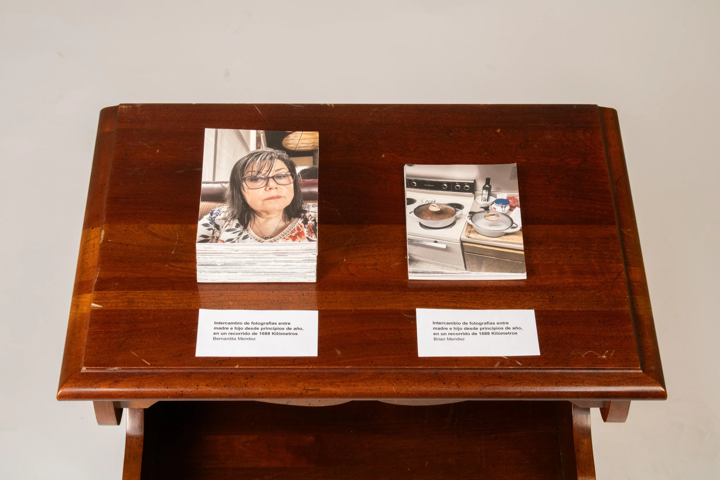 Intercambio de Fotografias entre Madre e Hijo, desde principios de Año, sobre
una Distancia de 1691.42 Kilometros. | 2025 | Interactive Sculpture | Inkjet Prints
and Found Furniture