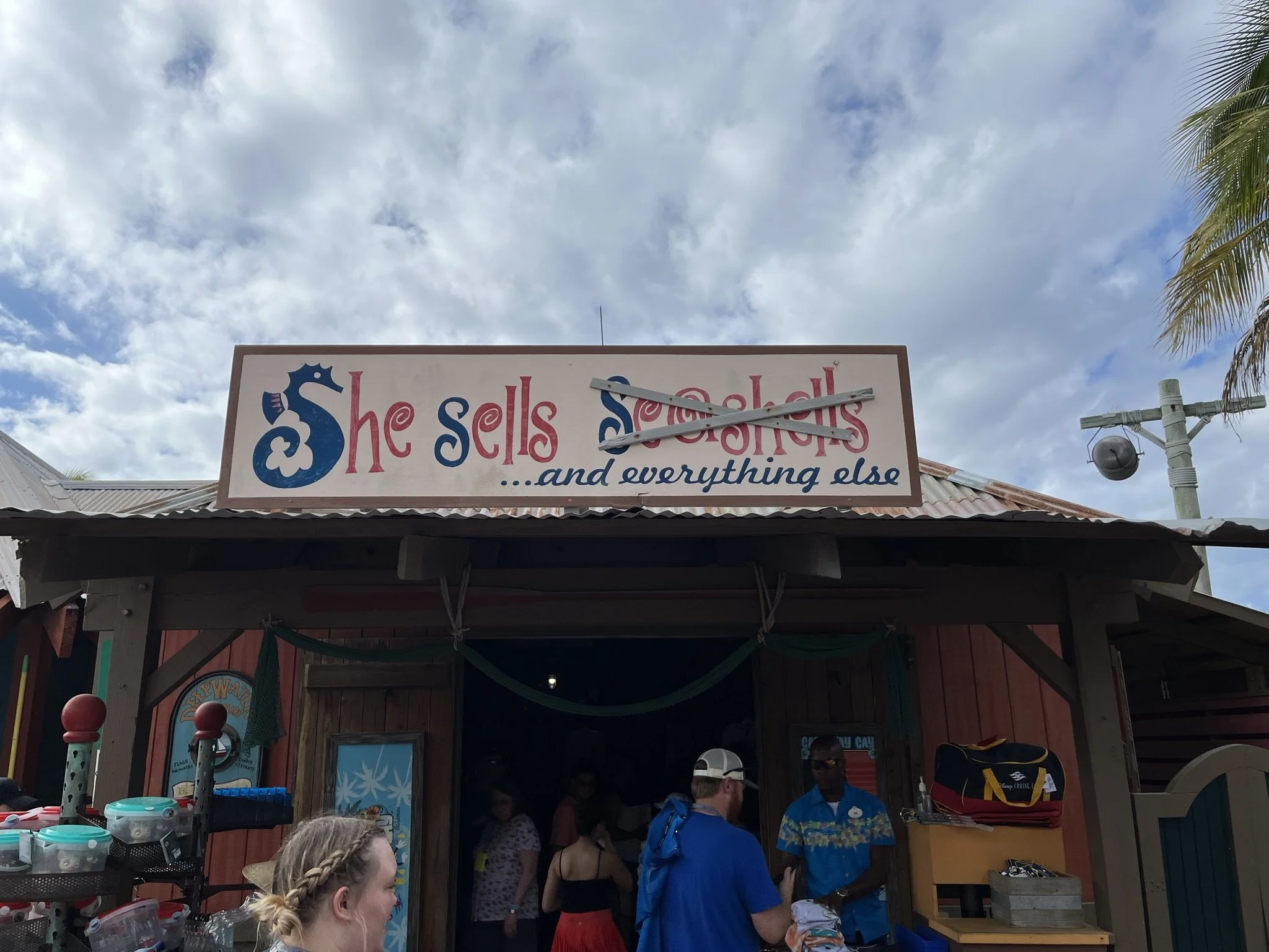 Een bezoekerskraam met een bord waarin staat 'She sells seashells ...and everything else', waarbij 'seashells' door een kras geplaatst is.
