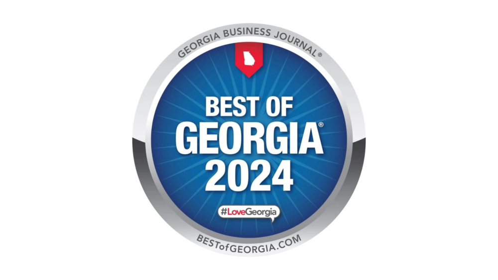 A circular badge with blue background and a silver border, featuring the red Georgia state outline at the top. The text reads "Best of Georgia 2024," with the Georgia Business Journal branding at the top and the website at the bottom, along with the hashtag #LoveGeorgia.