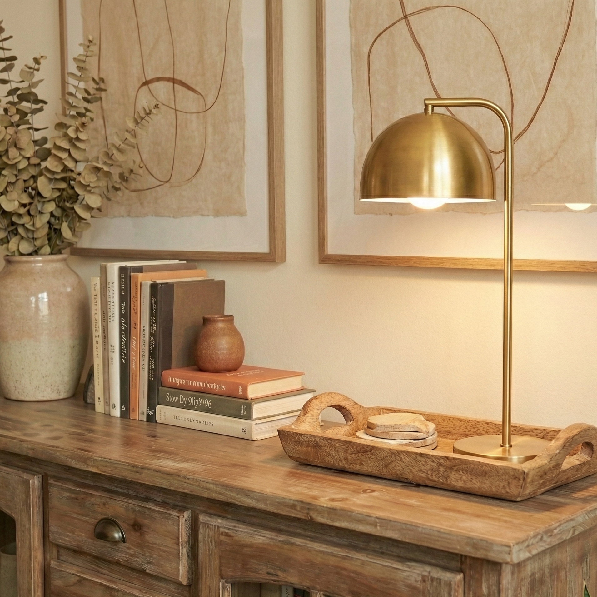 Close up of the top of a therapy office's credenza with a modern brass table lamp, tray, and psychology books