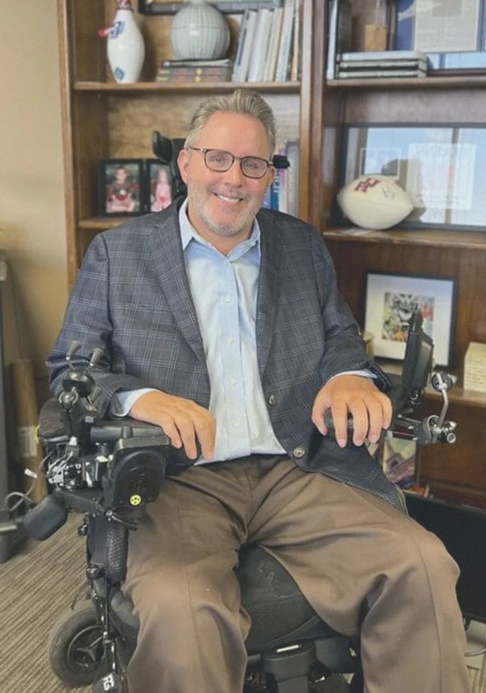 Toby Cole, pool injury attorney, seated in his wheelchair and smiling in his office.