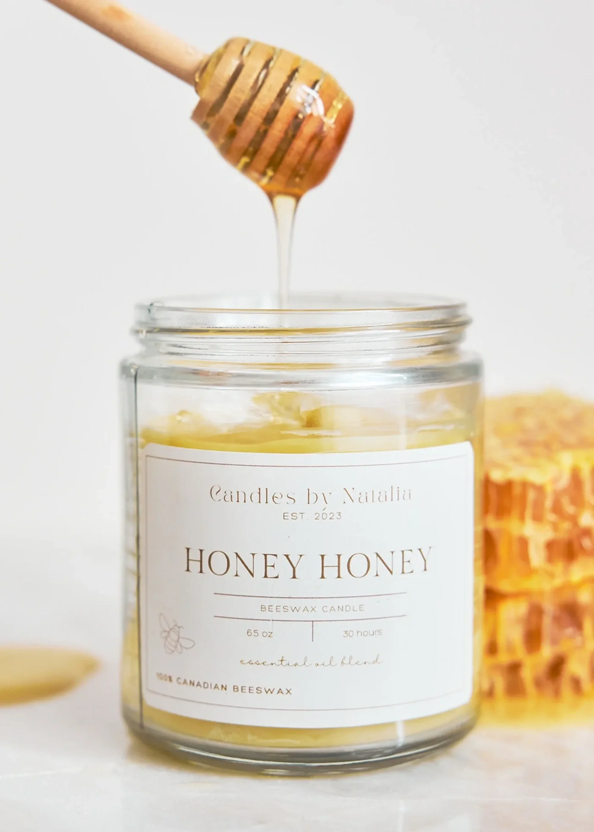 Honey Honey candle with a honey dipper dripping Honey overtop of it