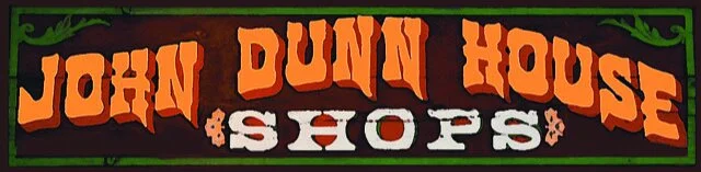 Sign reading 'John Dunn House & Shops' with orange and white text on a dark background.