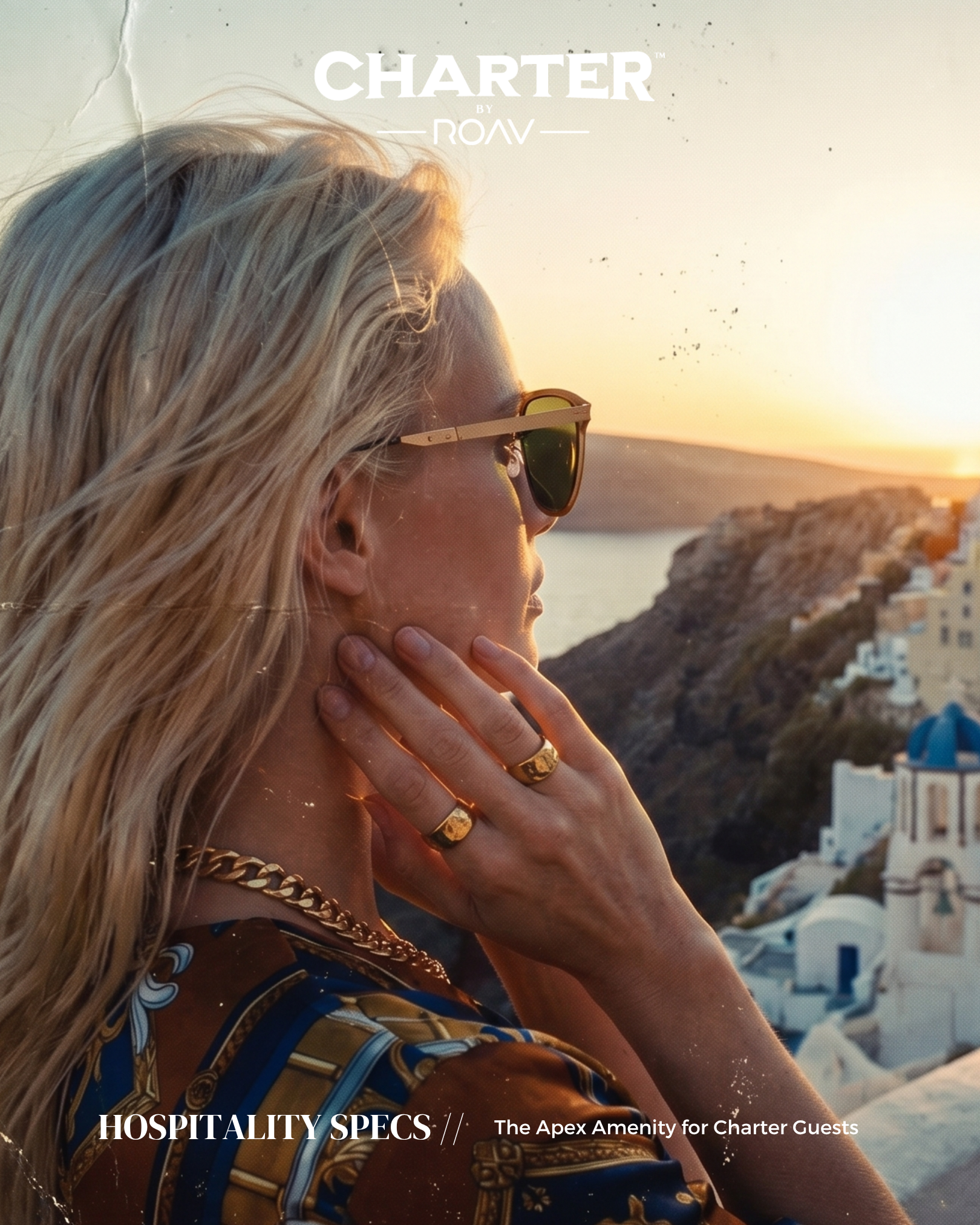 A woman with long blonde hair, wearing sunglasses and gold jewelry, is looking at a sunset over a coastal town with white buildings, in a scene resembling a Mediterranean seaside village.