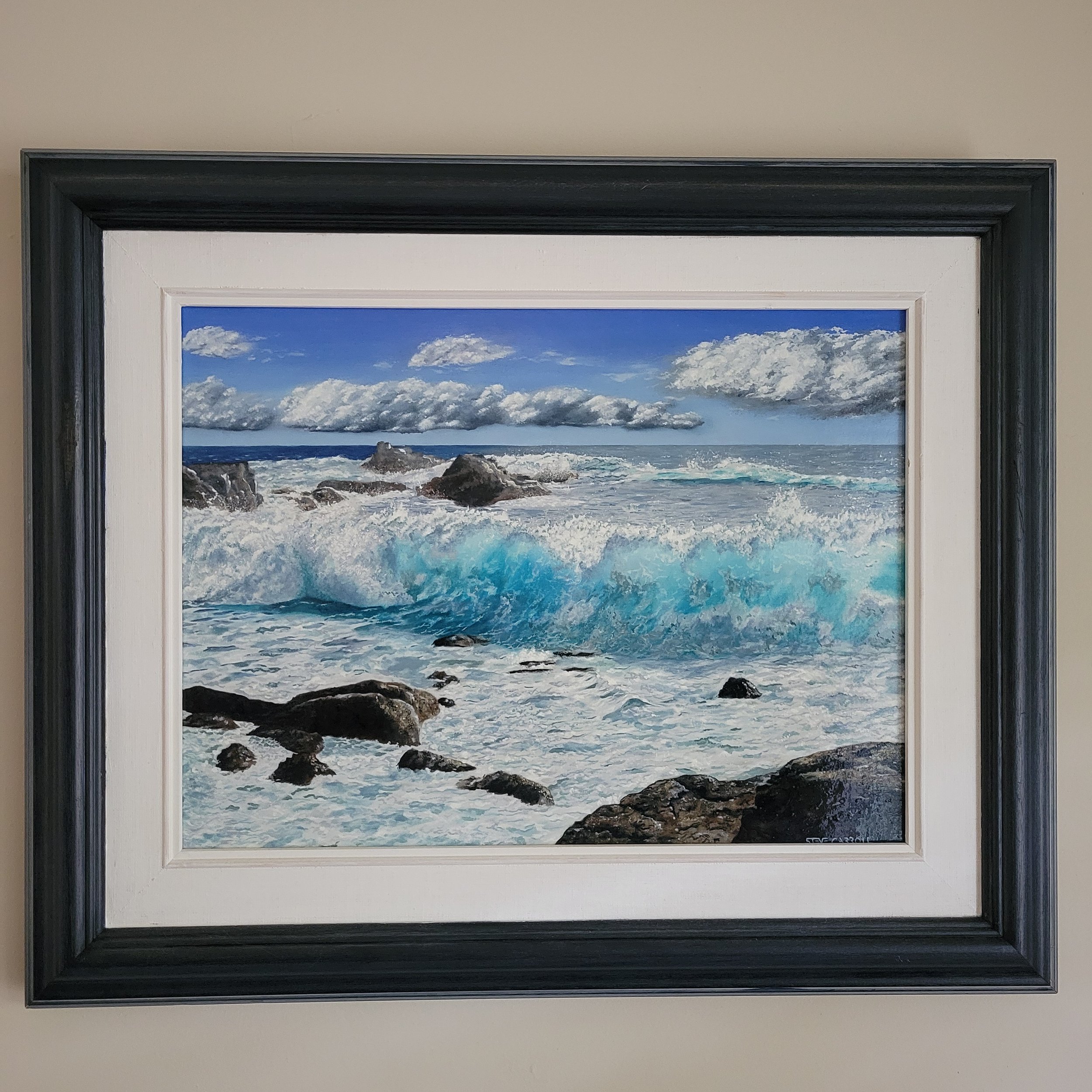 Artist Steve Carroll's oil painting of a blue ocean with crashing waves and rocks under a partly cloudy sky