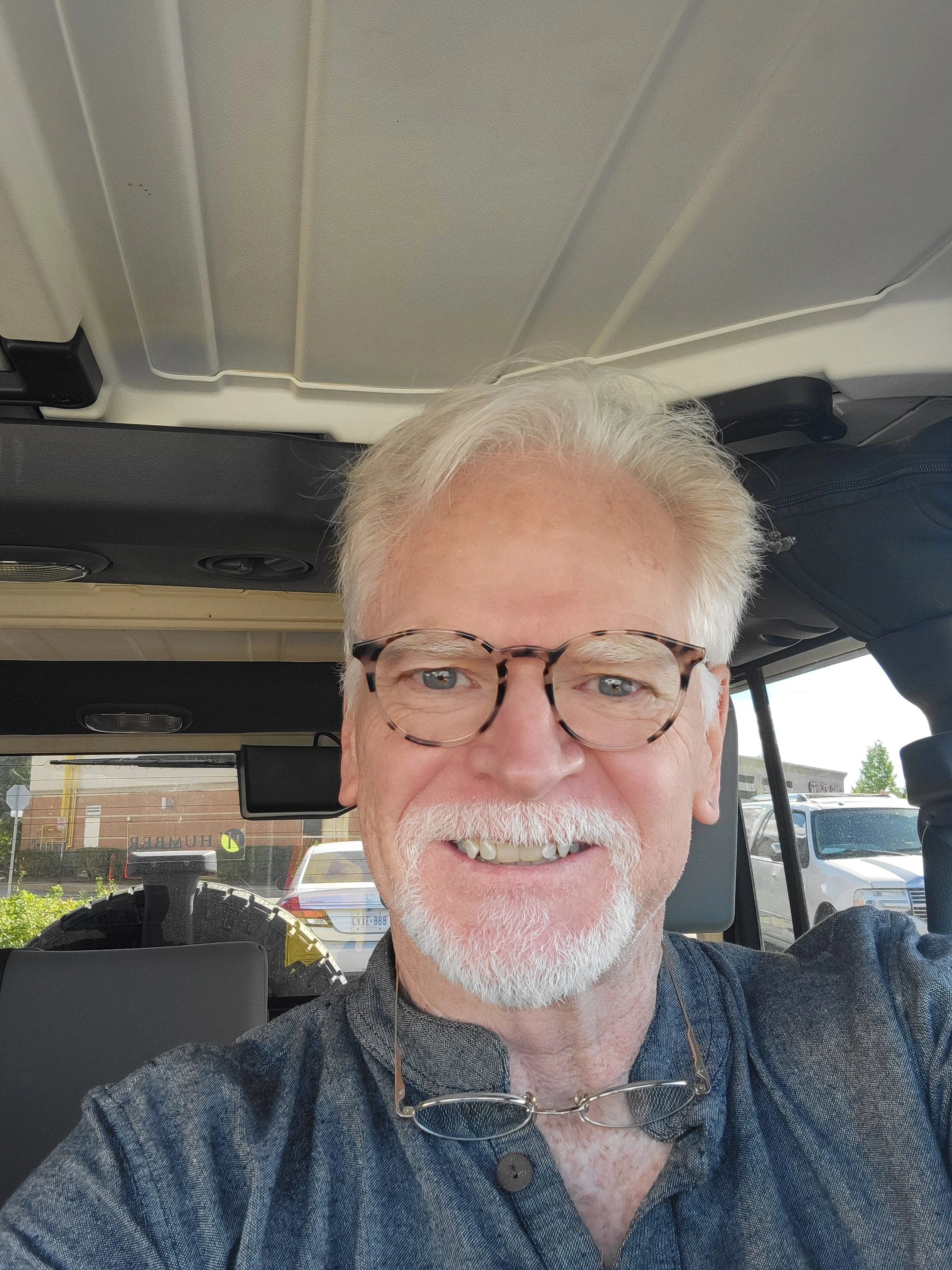 Artist Steve Carroll smiling inside his Jeep after a successful art show in Mississauga Ontario.