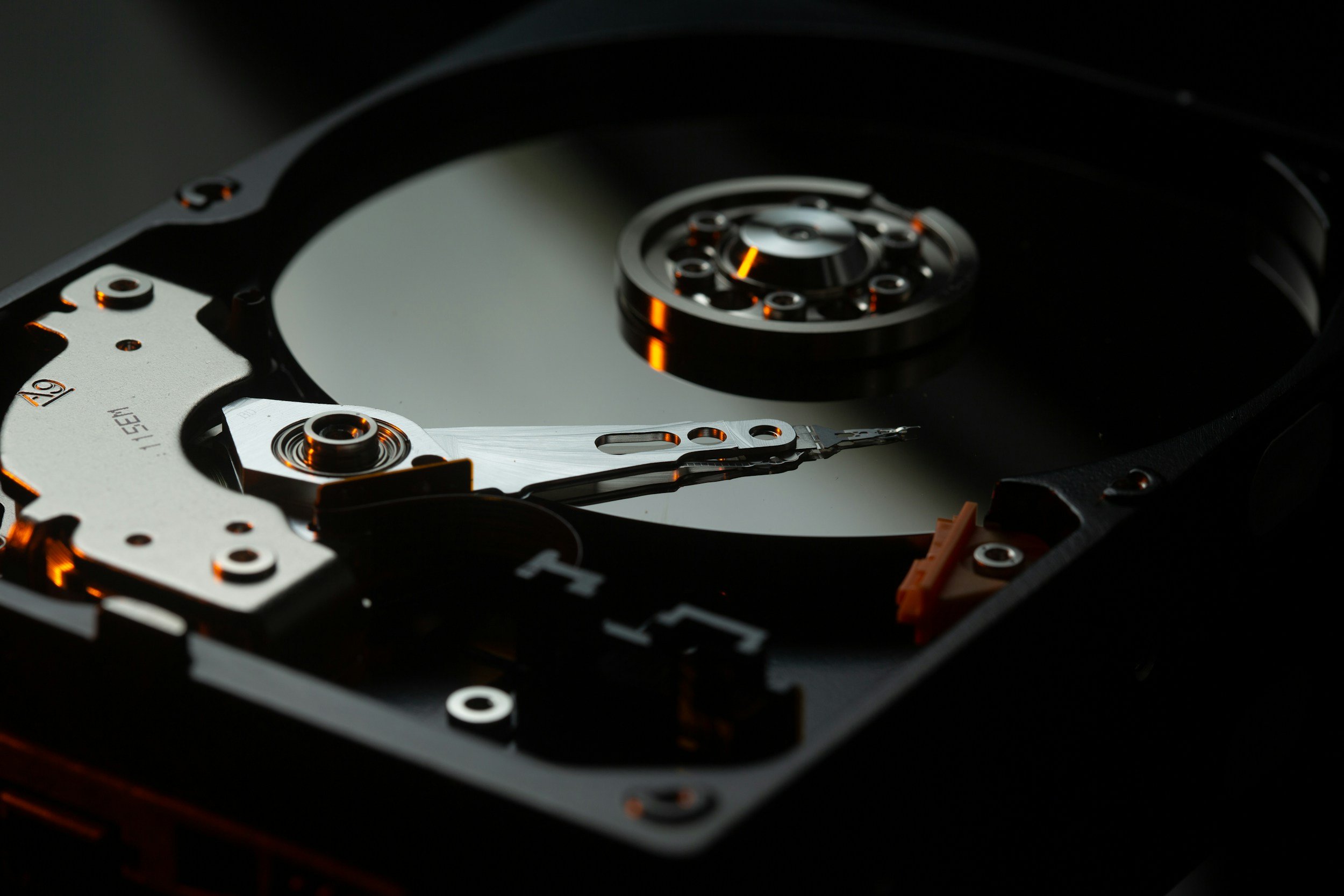 Close-up of the internal mechanical components of a hard disk drive, showing the shiny circular disk platters and read/write head.