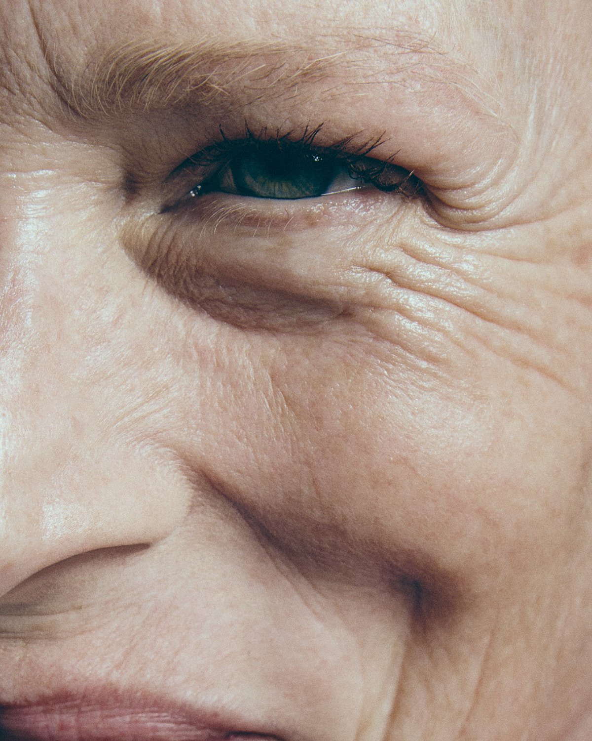 Close-up of an elderly person's face, focusing on the eye area, showing wrinkles and fine lines around the eye.