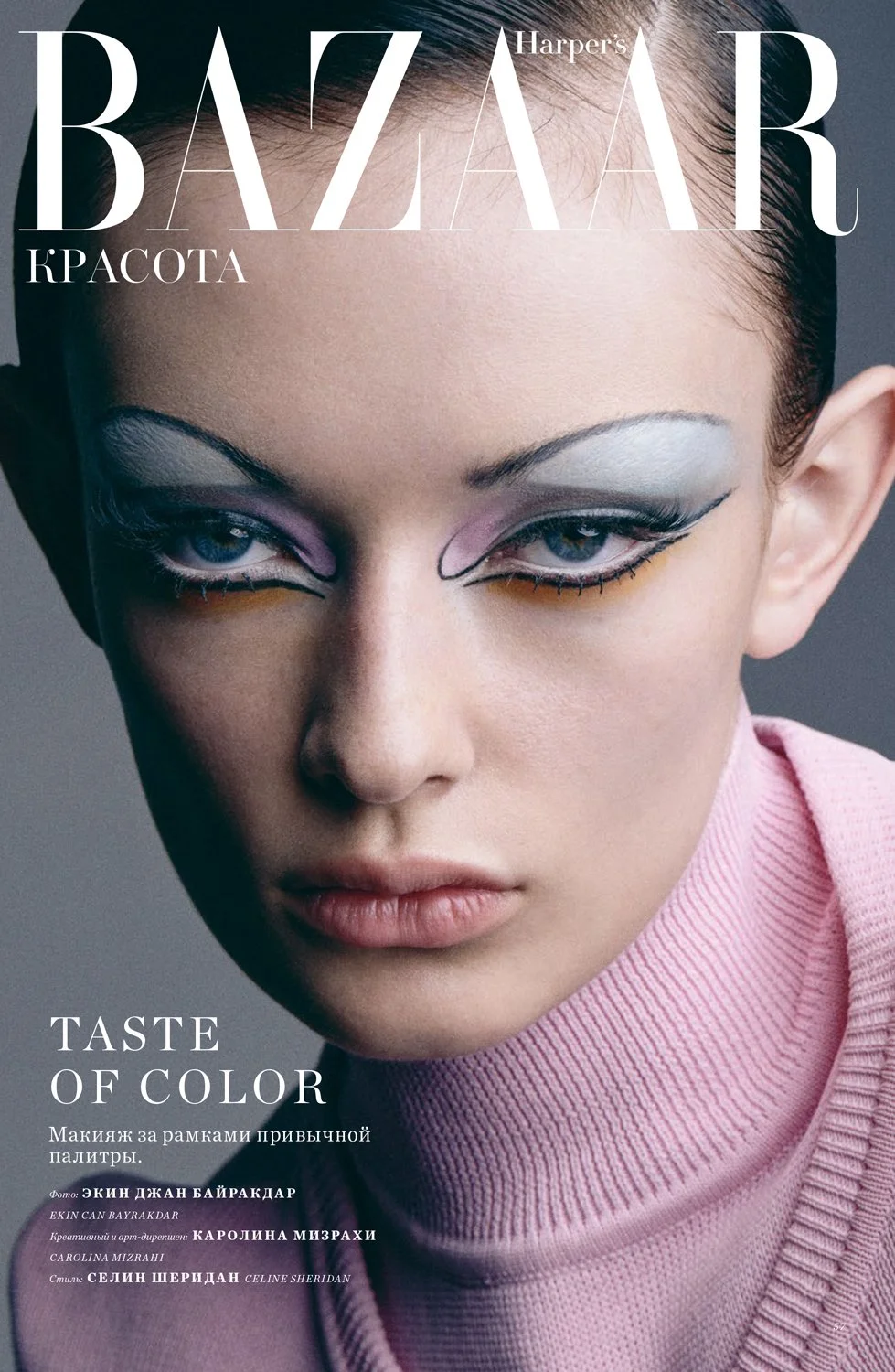 Close-up of a woman with bold eye makeup, wearing a pink turtleneck, on the cover of Harper's Bazaar magazine.