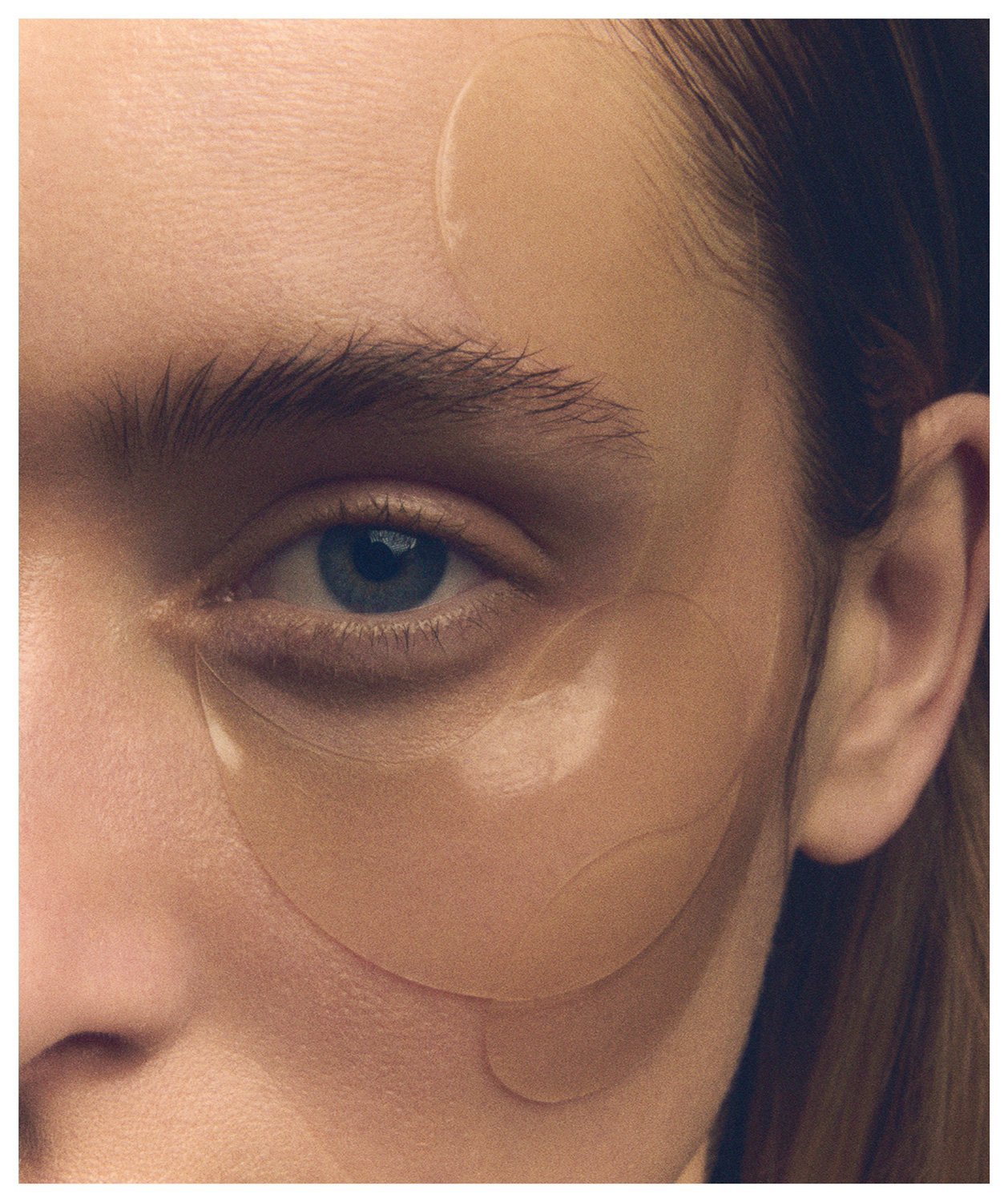 Close-up of a person's face showing an eye and an under-eye patch.