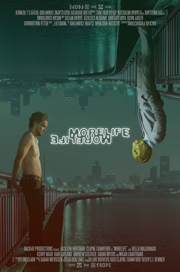 A promotional poster for the film 'More Life', showing a shirtless man standing on a bridge on the left and a woman with blonde hair in a gray suit hanging upside down from the bridge on the right. The city skyline is in the background. The title is 